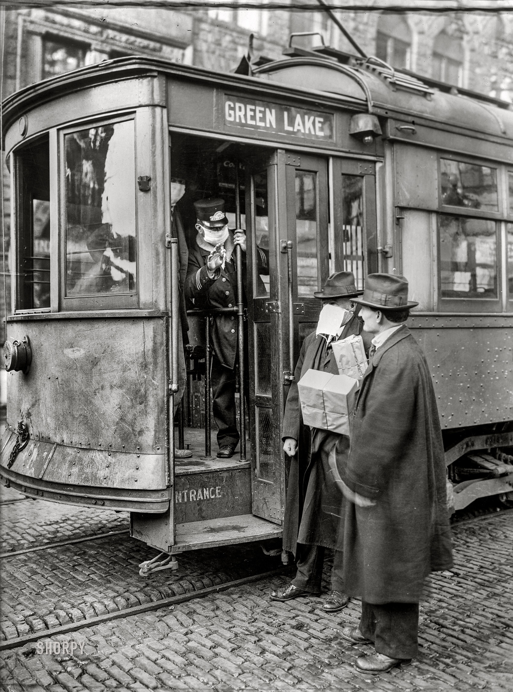 Ca. 1918-1919. "Precautions taken in Seattle, Wash., during the Spanish Influenza Epidemic would not permit anyone to ride on the street cars without wearing a mask. 260,000 of these were made by the Seattle Chapter of the Red Cross which consisted of 120 workers, in three days." 5x7 glass negative, American National Red Cross Photograph Collection. View full size.