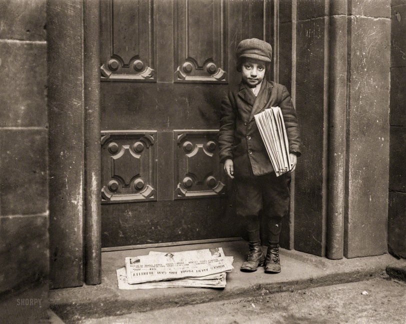 "Newsboy, 1913. No caption card found. Date based on captions for neighboring numbers. 'Pittsburg' may be in text at top of newspaper on ground, but neighboring newsboy photos taken in New York. Headline appears to be 'Judges Avert Probe and Save Blakeley'." Photo by Lewis Wickes Hine for the National Child Labor Committee. View full size.
