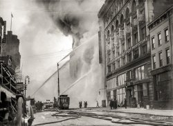 December 20, 1909. "Firemen spraying burning building on West 14th Street, New York." 5x7 glass negative, Bain News Service. View full size.
&nbsp; &nbsp; &nbsp; &nbsp; Three million gallons of water from the high-pressure mains were pumped into a fire that destroyed a large seven-story factory and loft building at 180-188 West Fourteenth Street yesterday morning, and for five hours the fire, which raged until the afternoon, completely cut off traffic on that street. The pavement and sidewalks and many buildings for almost a block were coated with thick mid-Winter ice. Fire and water together provided a spectacle for thousands of Christmas shoppers who crowded both sides of the street.
&nbsp; &nbsp; &nbsp; &nbsp; Although there were no injuries from the fire, it caused damage of $200,000. Workers at the training school of the Salvation Army headquarters, adjoining the building on the east, were routed from their beds. It is not known what started the fire.
-- New York Times, 12/21/1909