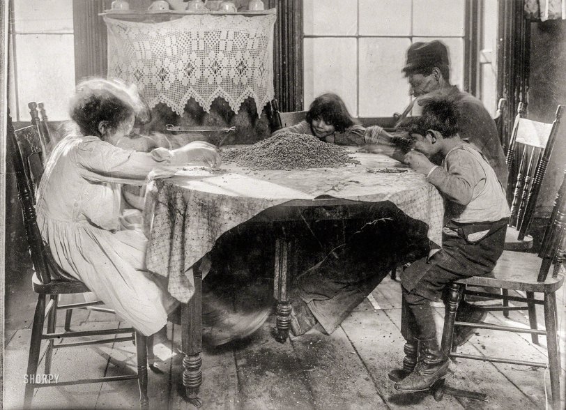 February 1910. "10 a.m. Saturday. 36 Laight Street, New York. Florence Lieto, 10 years old; Jennie Macola, 10 years old (hidden); Mamie Macola, 8; Nicholas Macola, 6. Picking coffee sweepings. The sweepings cost 25 cents a sack at the warehouse, and picked-over coffee sells at about 12 cents a pound. Man working with sore hand tied up in bandage. Children work after school hours and on Saturdays." Photo by Lewis Wickes Hine. View full size.
