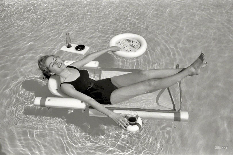 April 1961. "Sunbathing with the latest swimming pool equipment, including a lounge chair with floating beverage holders and game table attachments." From photos by Bob Sandberg for the Look magazine assignment "For Women Only -- Pool Life." Tell your kids about how back in the day people couldn't play cards or smoke in the pool, and all you're likely to get is a blank stare. View full size.
