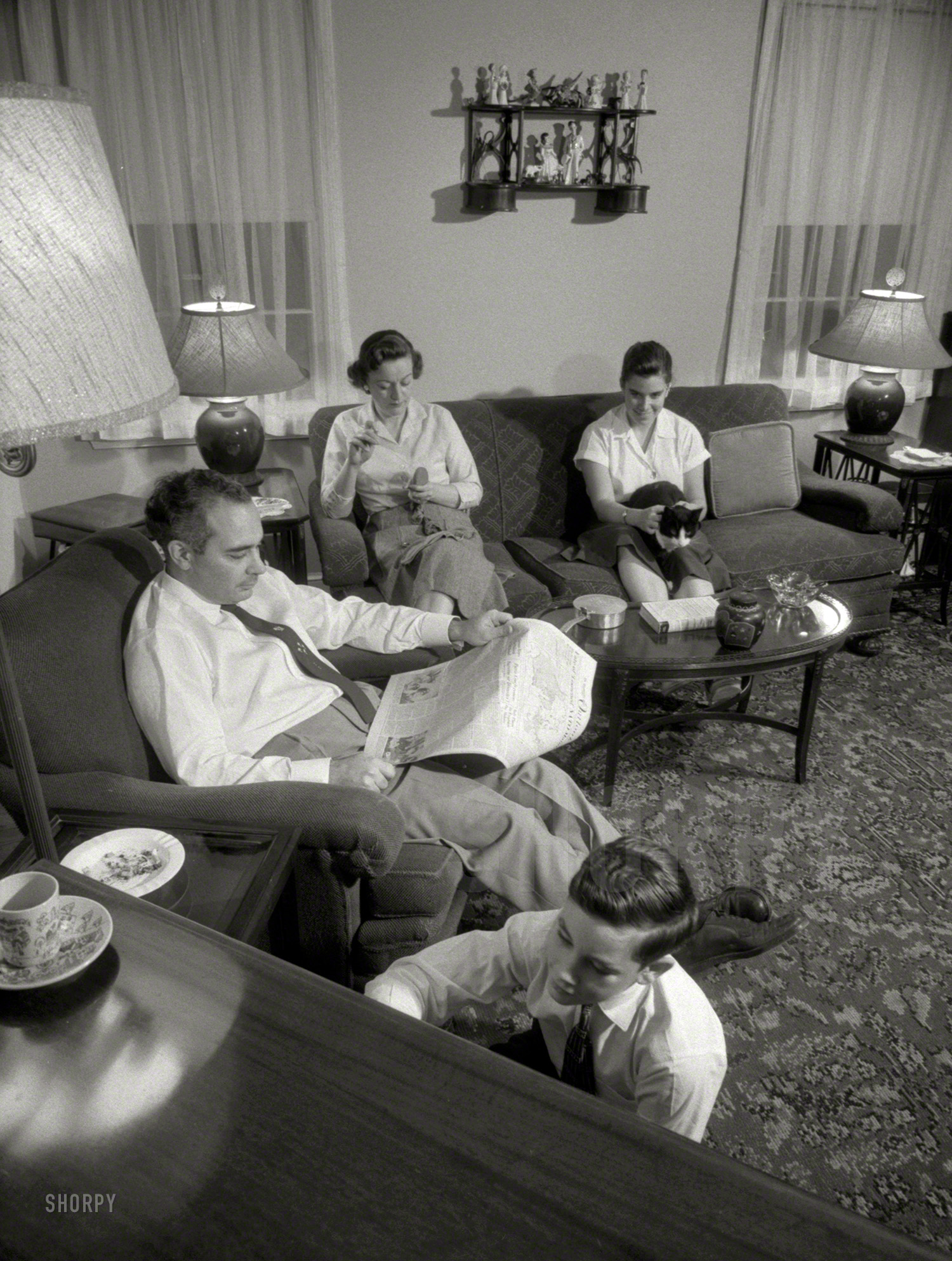 December 1957. "Family listening to radio." Mother sewing; Father reading; Sis petting; Junior tuning. 35mm negative by Warren K. Leffler. View full size.