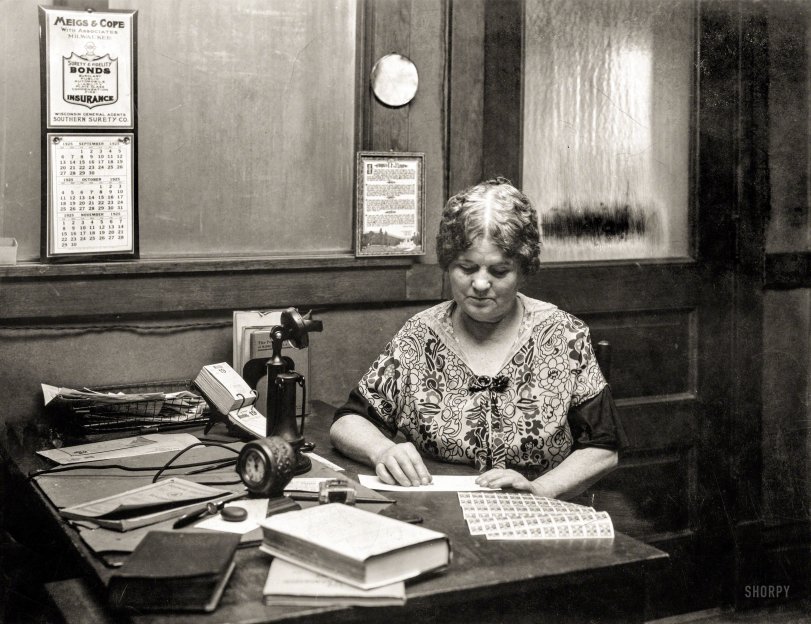 There's no caption for this yellowing print of a lady at an office desk with postage stamps (quite possibly on October 19, 1925). Yet there must be some reason it's in the Library of Congress Prints &amp; Photographs Online Catalog. View full size.
