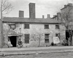 Fredericksburg, Va., circa 1927. "Tenement, 203 Charlotte St., residence of 'Gover&shy;nor Hill.' Photo taken on commission from Mrs. Devore of Chatham." Note the head-on-a-pike signage. Photo by Frances Benjamin Johnston. View full size.