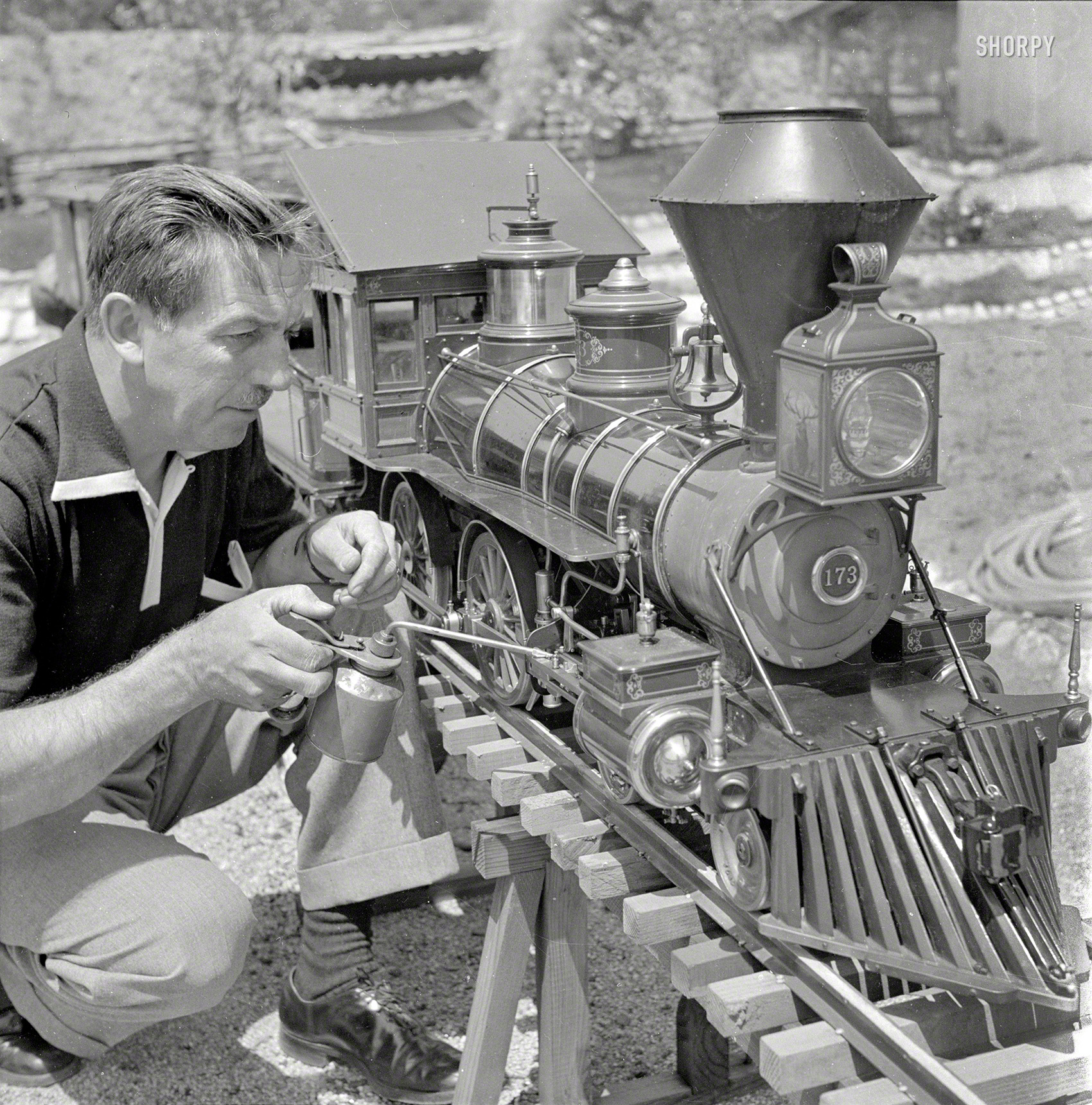 September 1951. "Walt Disney oiling parts of the locomotive of his scale model steam railroad, the Carolwood Pacific Railway, in the backyard of his house in Los Angeles." Medium-format nitrate negative by Earl Theisen for the Look magazine assignment "Walt Disney's Giant Little Railroad." View full size.