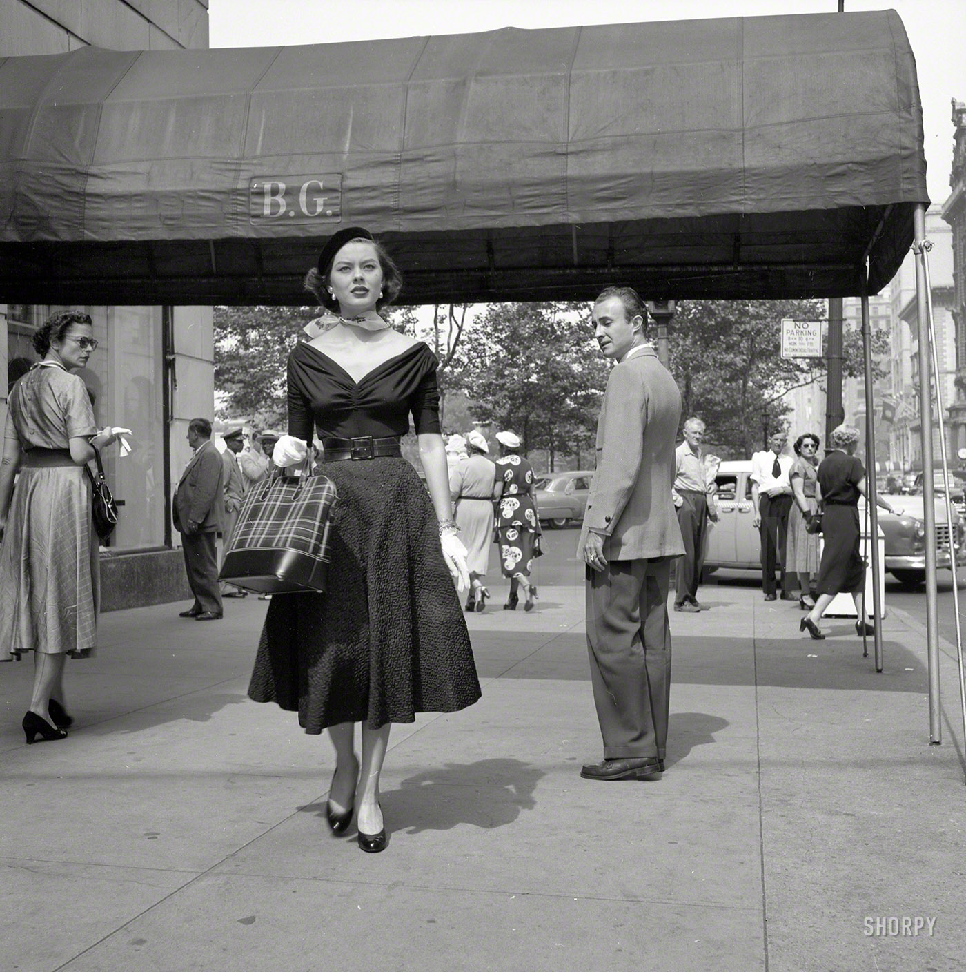 September 1952. New York. "Photos show people looking at fashion model Doris Erwin as she walks down Fifth Avenue." Just passing Bergdorf Goodman. One of three dozen images snapped by Ralph Ginzburg for the Look magazine assignment "A Young Man's Fancy -- Model on the Street." View full size.