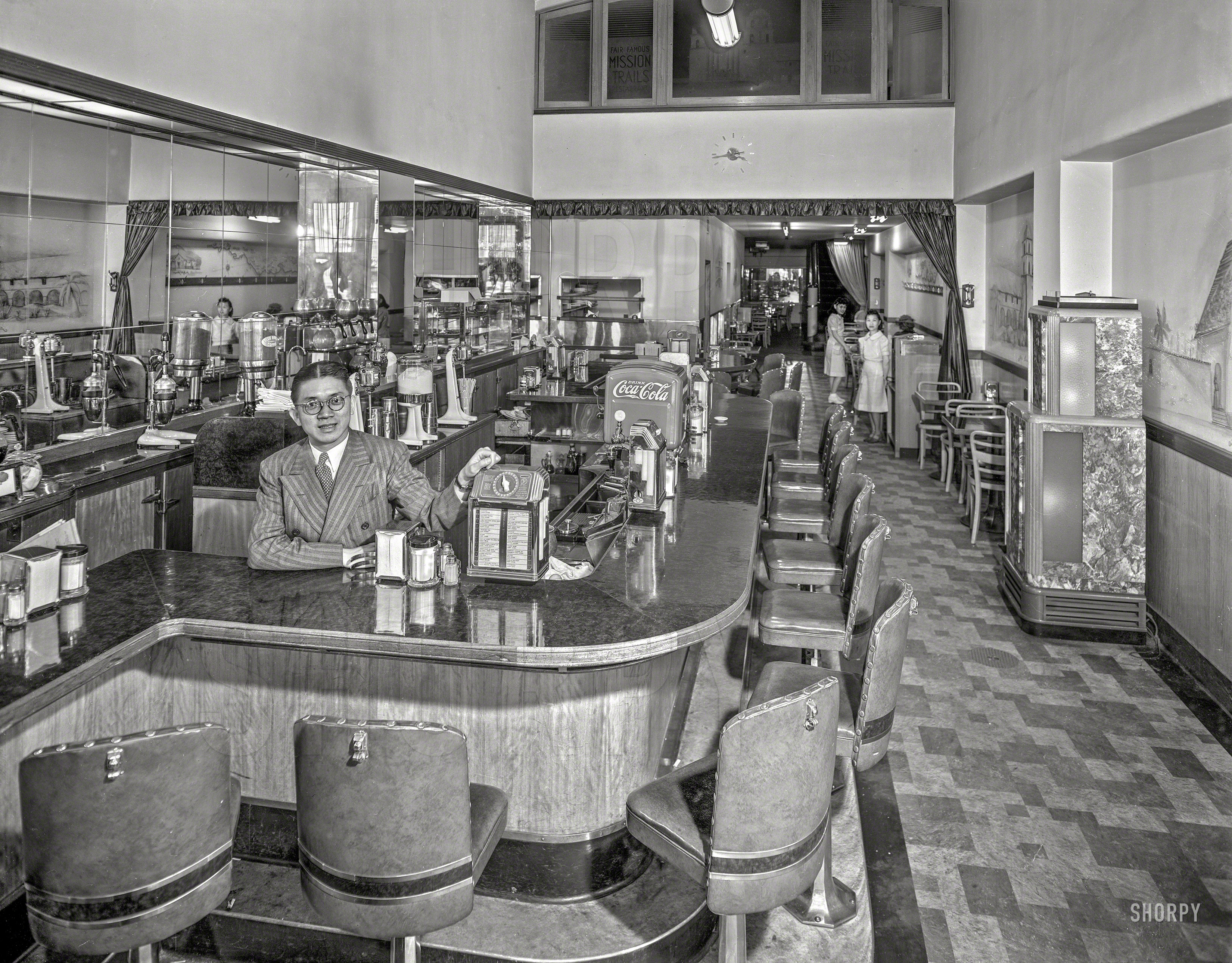 It's 1942 and we're back in San Francisco for another look at one of the many fine establishments made even finer by the installation of Buckley Music System's "Music Box." The eatery is Andy Wong's "Fair Famous" Mission Trails Restaurant, Harvey Lum, manager, at 500 Sutter Street. Close your eyes and you can practically hear Padre tolling the mission bell while the brothers pound out their tortillas. 8x10 inch acetate negative, photographer unknown. View full size.