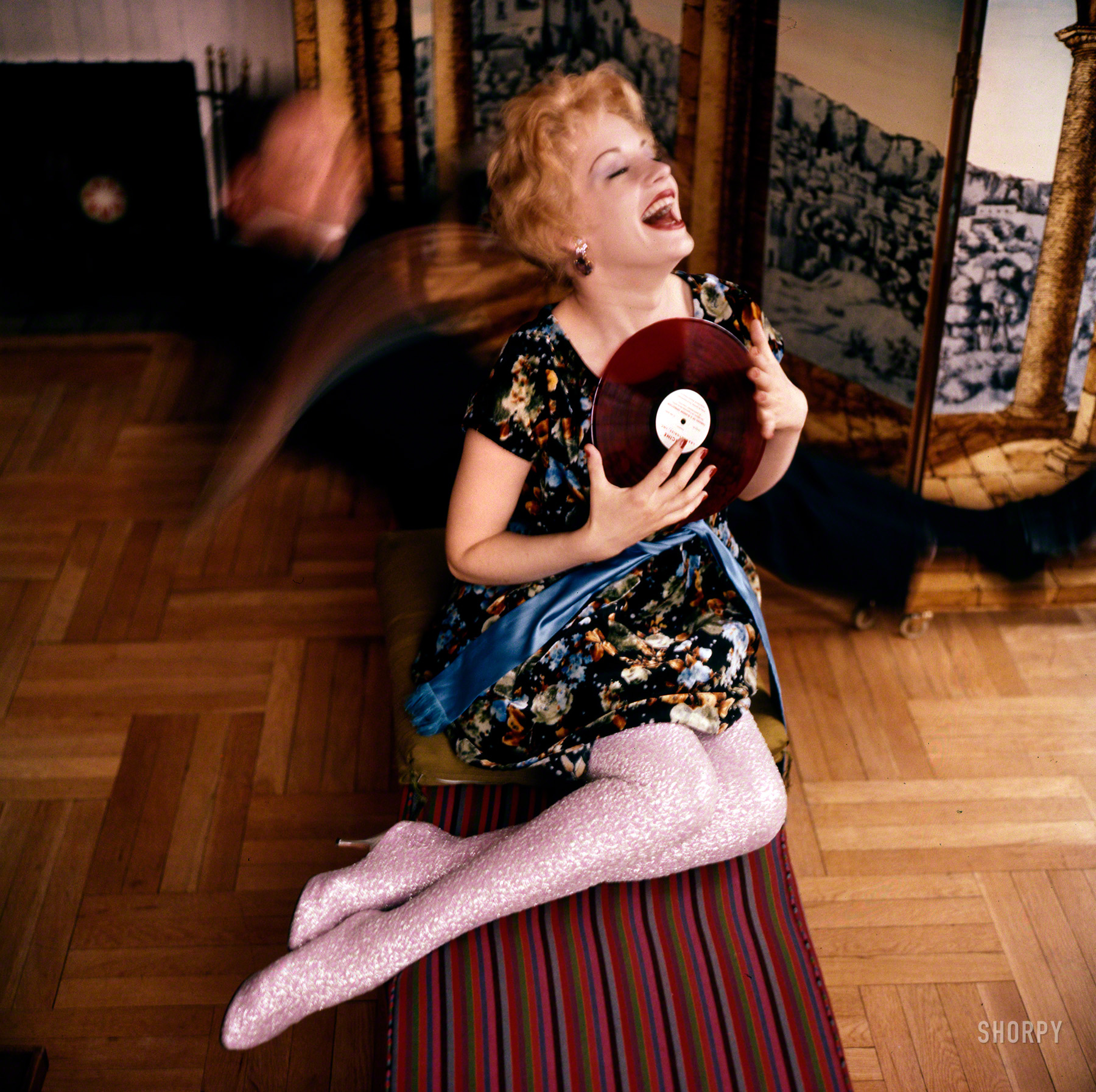 May 1958. "Actress Mary Ure wearing silver lamé, thigh-high leg covering with attached heels." The record is  Norgine Laboratories' 78 rpm pressing of Marin Marais's "Tableau of a Bladder Operation." Color transparency from the Look magazine assignment "For Women Only: Crazy With the Heat." View full size.