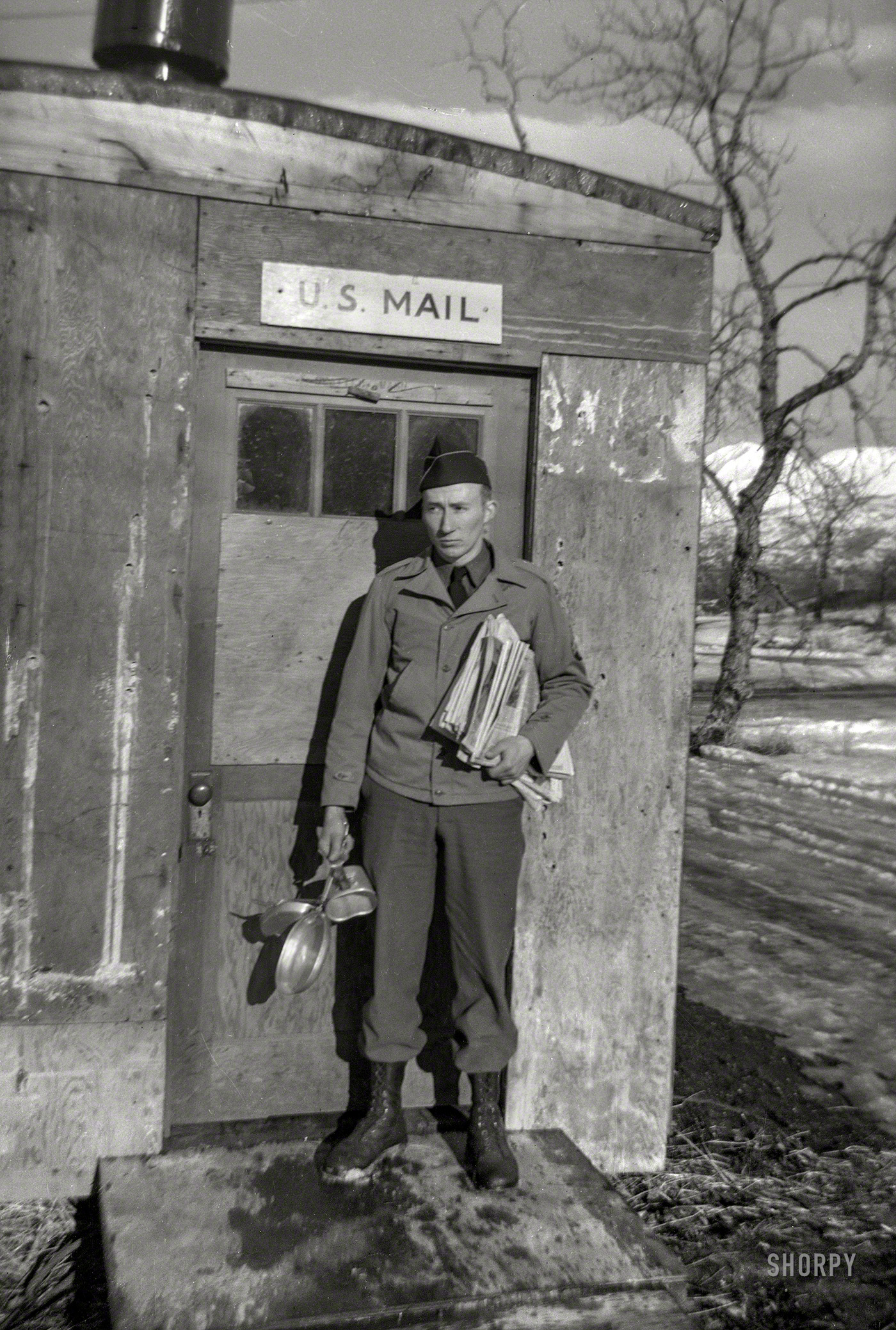 Circa 1942. "Alaska Defense Command. At mail shack with mess kit." And now to catch up on the news! 120 film negative from an estate sale. View full size.