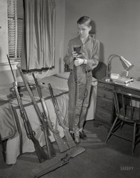 From Columbus, Georgia, or vicinity circa 1959 comes this uncaptioned shot of the young marksman last seen here. 4x5 inch acetate negative. View full size.
We need a reason to raise families again.There were a lot more guns back then. Kids brought them to school and schools had shooting clubs. What went wrong? People changed their values. Life just doesn't hold the same value as it used to especially when kids play games that provide extra points for finishing the wounded off. Tighten your seat belts, it's going to be a bumpy ride.
[There were not "a lot more guns back then." - Dave]
You're correct, there are more guns today, but less gun holding households. Since they are primarily manufactured for domestic use, it translates to more guns per holding household. Accordingly, 3% of the population own half the guns in the US while gun manufacturing numbers have increased since at least 1972. In any case, it's the psychology that has changed most drastically.
Gun Ownership in America
No high end rifles thereBut I do like the pneumatic pump up rifle next to the young man. Crosman or Benjamin 5.5 mm or .20 caliber
Kids and GunsIn that day and age kids were taught gun safety and were trusted not to misuse them. Today they only know what they see on TV, which is the misuse of them.
Real Penny LoafersIt’s been many a year since I’ve seen pennies in penny loafers!  When I grew up in Texas in the 1950s, adults and kids had guns, but they were used for hunting and plinking. They were not misused. Guns in racks in pickup trucks were not given a second glance.  My how times have changed.
RE: What Could Possibly Go Wrong?Sulzermeister, just so you know (this coming from a once-Texan no less), not everyone on this side of the pond thinks gun ownership is a good thing.  In fact, I'd like to think it is a majority of Americans who shudder a bit at the thought of a kid with an arsenal like this in his bedroom.
What Could Possibly Go Wrong?From the UK side of the Atlantic this looks pretty odd.
I'm not aware of any of our considerable list of friends here in Scotland actually owning or possessing a firearm!
A boy and his bayonetI'm not a gun enthusiast. While I can understand that a kid from Georgia might want a rifle, and a few more rifles, and a shotgun, maybe someone can explain why he needs a bayonet. 
When onejust isn't good enough.
Arisaka Type 44 CarbineI could be wrong on the exact identification but the weapon on the extreme left is a Japanese Arisaka Type 44 carbine. The bayonet is actually a part of the carbine and is not easily removable. It folds underneath the stock. The boy simply has it extended. This weapon could have been a bring-back by his dad or other relative during World War II as at the time the US military allowed certain captured weapons to be sent home. The amount of rifles/carbines is not unusual for a boy of the period especially in rural areas or the South. My dad and his brothers for instance, around the same year as the photograph was taken, had quite a few rifles. They lived on a farm and hunted game with them or just did target practice. 
Army bratThere was some speculation in the previous iteration of this young man that his father may have been a Marine due to the Arisaka rifle.  Columbus is right next to Fort Benning, so it's more likely than not that his father was in the Army. The US Army fought in the Pacific too, most notably in New Guinea, the Philippines, and Okinawa. It's even possible that Dad was still in the Army and stationed at Fort Benning (where I took basic training almost 50 years ago). It's also possible that most of the weapons on display belong to Dad too. 
The term "Army brat" is a term of pseudo-affection given to children of career Army soldiers.
Fountain PenI suspect our marksman was using a fountain pen, since I see the familiar bottle of Sheaffer Skrip ink. It came in a number of colours, such as blue black and emerald green. But only the girls would dare use green ink. I still have a jar of jet black Skrip ink, now mummified. The jar featured a little reservoir to fill the fountain pen easily.
Cadet Corps was compulsory in Windsor, Ontario high schools in 1964, and we had to learn how to dismantle a gun and clean it. We also did target practice with .22s down at the shooting range in the basement. 
Keep them cleanI'm guessing he is putting his firearms away since the shotgun is no longer on the left end of the bed.  And those might be used patches on the bedspread.
I know I would not want my mom seeing those patches and cleaning rod on my bed.  They'd have been cleaned up first!
Course, if I knew the time stamp on the pictures it would confirm putting away or taking out.
Times have changedI graduated high school in 1969. From the 7th through 12th grade the school had a rifle club whose members would shoot in the basement firing range. This, mind you, was about eight miles from downtown Boston. These days people would freak out just seeing a photo of the rifle club. To my recollection, there were no incidents of gun violence involving anyone in the schools.
Arisaka RifleI agree that the rifle on the far left is likely a war prize Japanese Arisaka rifle. My late great uncle brought one back from his stint as a U.S. Marine fighting on Guadalcanal Island. We had it in our household for a period of time when I was a kid (I was fascinated by it), but my uncle at some point took it back and no telling where it ended up.  He returned from combat a profoundly changed man and lived the rest of his life as a delusional drunkard - a victim of PSTD before it was a widely-recognized affliction. 
What folks knew in &#039;59Clearly, no one is going to change anyone else's mind on gun issues.  But, in spite of what a couple of the comments posted here might suggest, could we at least agree on the proper use of "less" vs. "fewer"?
The Real DangerThe young lad could easily get tangled in the venetian blind cord and strangle himself in his sleep. Those cords are real killers!
Words of WisdomIn the word of Santa Claus and Ralphie's mom, "You'll shoot your eye out, kid!"
Speaking of bayonetsI’ve always wondered about the dual nature of a rifle with a bayonet affixed, making it a weapon both to shoot and to stab.  Which raises the following macabre question: does not the function of the bayonet sometimes result in an impaired function of the rifle as a shooting weapon?  In other words, doesn’t the muzzle sometimes get clogged with blood and gore, resulting in a blocked rifle, making it impossible or even dangerous to shoot?
Dime a Dozen SpringfieldSecond from left looks like a Springfield .58 from the Civil War.  It has been cut down a bit and is missing the original barrel bands.  Looks like someone put an Enfield barrel band on it.  My dad said when he was a kid, these rifles were a dime a dozen, with many being cut down and used as shotguns.
A decent Springfield of Enfield will set you back at least $1500 now.
On that bayonetIt's probably a war prize.  Is it a huge risk?  Not really, as the gun it's mounted on is far more lethal than it is.  David Grossman, who made a career out of teaching soldiers to kill (it's evidently harder than you'd think), characterized the use of the bayonet as one of the hardest things to teach simply because it by definition is a close up killing.  
RE: What Could Possibly Go Wrong?kines - I' glad to hear your take on this.
Sorting gun ownership in the USA will take time and there are numerous "interested" parties but I hope you'll eventually reach the near-zero figure we have in Scotland!
RE: Keep them cleanThere IS a time stamp on the photo. It is on the desk and shows about 4:25. I have to assume it is in the afternoon as his hair looks too nice to be 4:25 in the AM 
(The Gallery, Columbus, Ga., Kids, News Photo Archive)