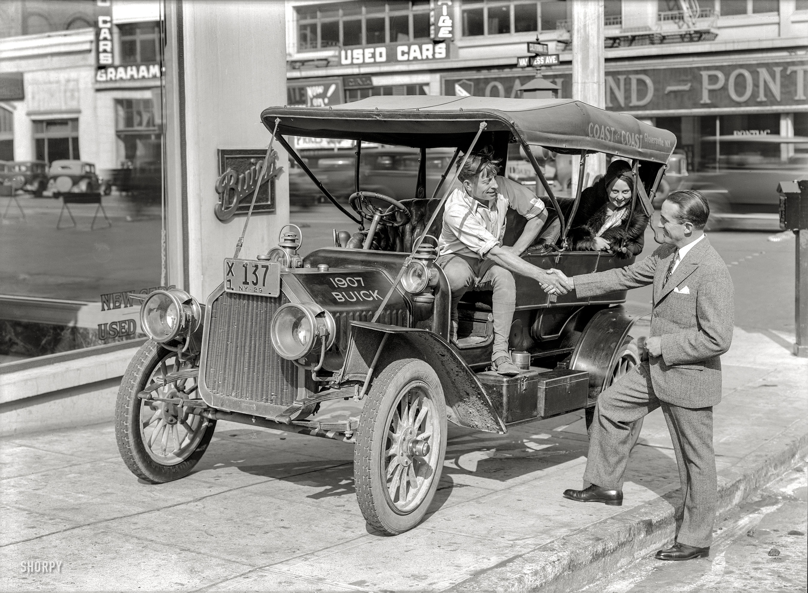 A 1907 "Coast-to-Coast" Buick on San Francisco's Auto Row at Van Ness Avenue and California Street in 1929, evidently at the end of its jaunt. Of all the marques represented here -- Buick, Graham-Paige, Pontiac and Oakland -- only Buick survives. 5x7 inch glass negative by Christopher Helin. View full size.