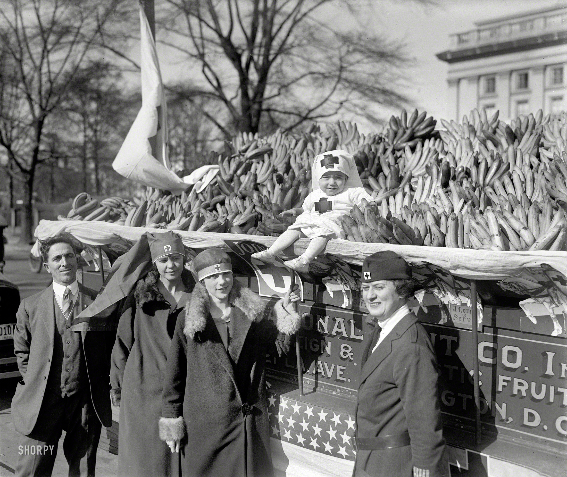 Nov. 14, 1925. Washington, D.C. "Auction of bananas for Red Cross." The baby is Josephine Scalco, whose father, Salvatore Scalco of the National Fruit Co., is standing at left and whose family was last seen here and here. View full size.