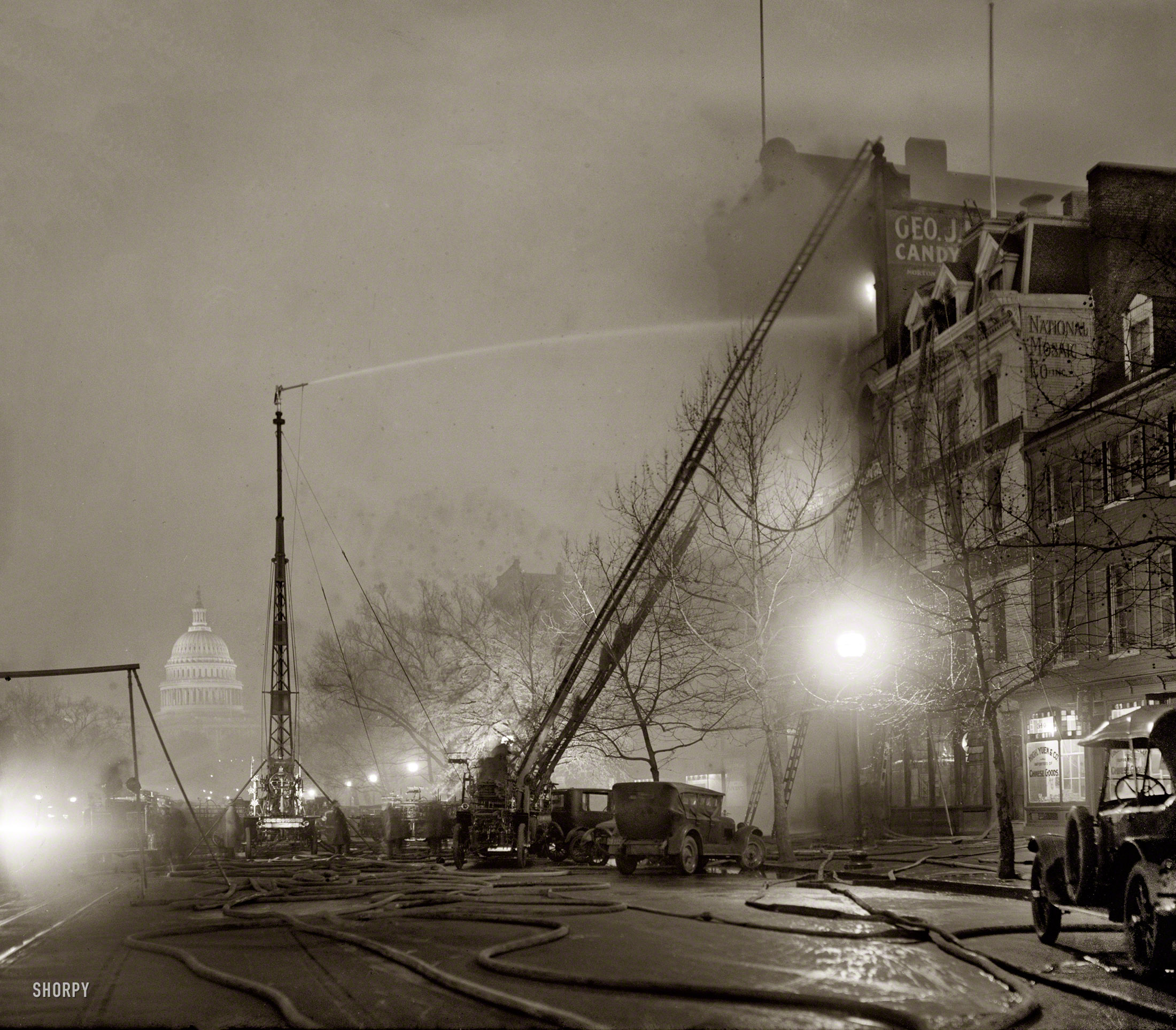 December 28, 1925. "G.J. Mueller Fire." A five-alarm fire at George J. Mueller Candy Co. in Chinatown at 336 Pennsylvania Avenue N.W., in view of the Capitol. National Photo Company Collection glass negative. View full size.