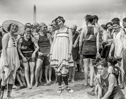 July 26, 1919. Washington, D.C. "Bathing beach parade at Tidal Basin." National Photo Company Collection glass negative. View full size.

GALAXY OF BEAUTY PARADES AT BEACH

Comely Damsels in Scant Attire Win Prizes for Their Appearance.

&nbsp; &nbsp; &nbsp; &nbsp; JULY 27 -- While more than 5,000 persons clambered to each other's shoulders and to roofs of nearby buildings to view the Annette Kellermanns at the first annual beach parade at the Tidal Basin yesterday afternoon, Mrs. Audrey O'Connor, 620 Maryland avenue southwest, was proclaimed by the judges as Washington's most beautiful girl in a bathing suit. Mrs. O'Connor wore a blue and orange jumper, blue cap and orange tights. Miss Dot Buckley, 1250 Tenth street northwest, received honorable mention in the contest. Her suit was a creation in red, white and blue.
&nbsp; &nbsp; &nbsp; &nbsp; First prize in the costume contest was awarded Mrs. Grace Fleishman, 5 Iowa circle, who wore a white silk suit with black and white border and a white silk hat. Miss Muriel Gibbs, costumed as Miss Liberty in stars and stripes, received honorable mention. Silver loving cups were awarded to the winners of both the beauty and the costume contests. 
&nbsp; &nbsp; &nbsp; &nbsp; Following the parade of the score or more of beauties between cheering crowds of bathing beach fans, the former faced half a dozen movie machines and a battery of press cameras. Later one of the winners obligingly did a modified "shimmy dance" for the movie men.