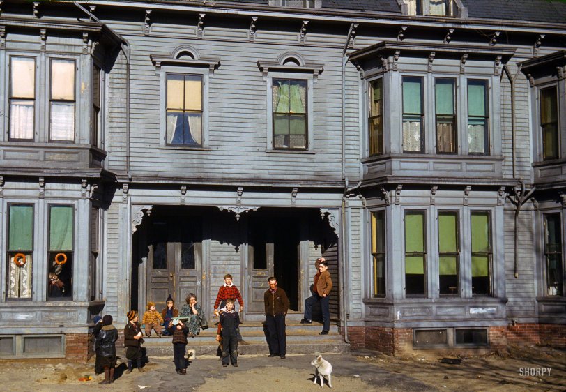 December 1940. "Children in the tenement district, Brockton, Massachusetts." These houses, which look to have been built in the 1890s, must have been imposing in their day. Note the elaborate woodwork and intricate system of gutters and downspouts. Kodachrome transparency by Jack Delano. View full size.
