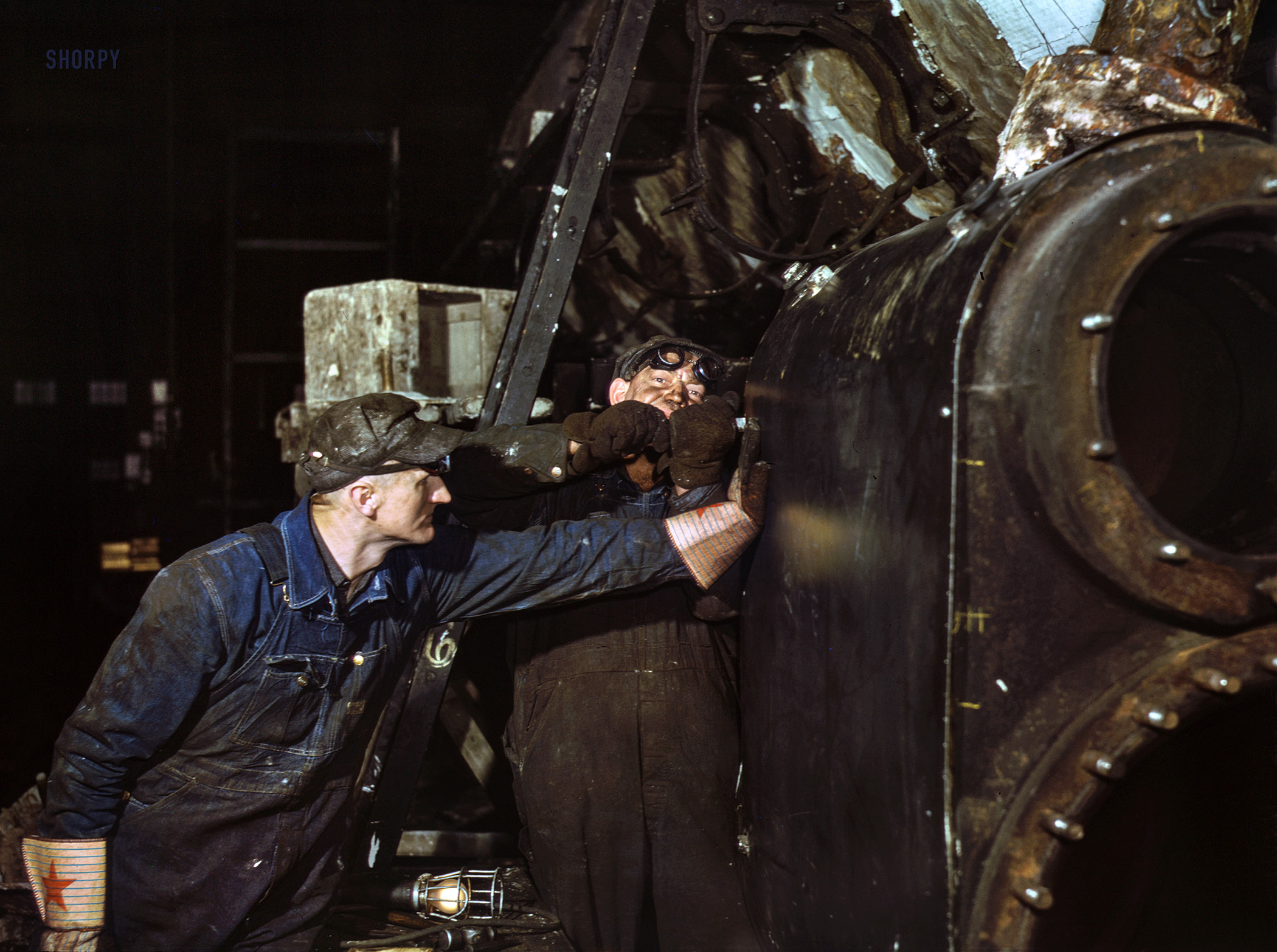 December 1942. "Working on the cylinder of a locomotive at the Chicago & North Western R.R. 40th Street shops, Chicago, Illinois." Kodachrome transparency by Jack Delano for the Office of War Information. View full size.