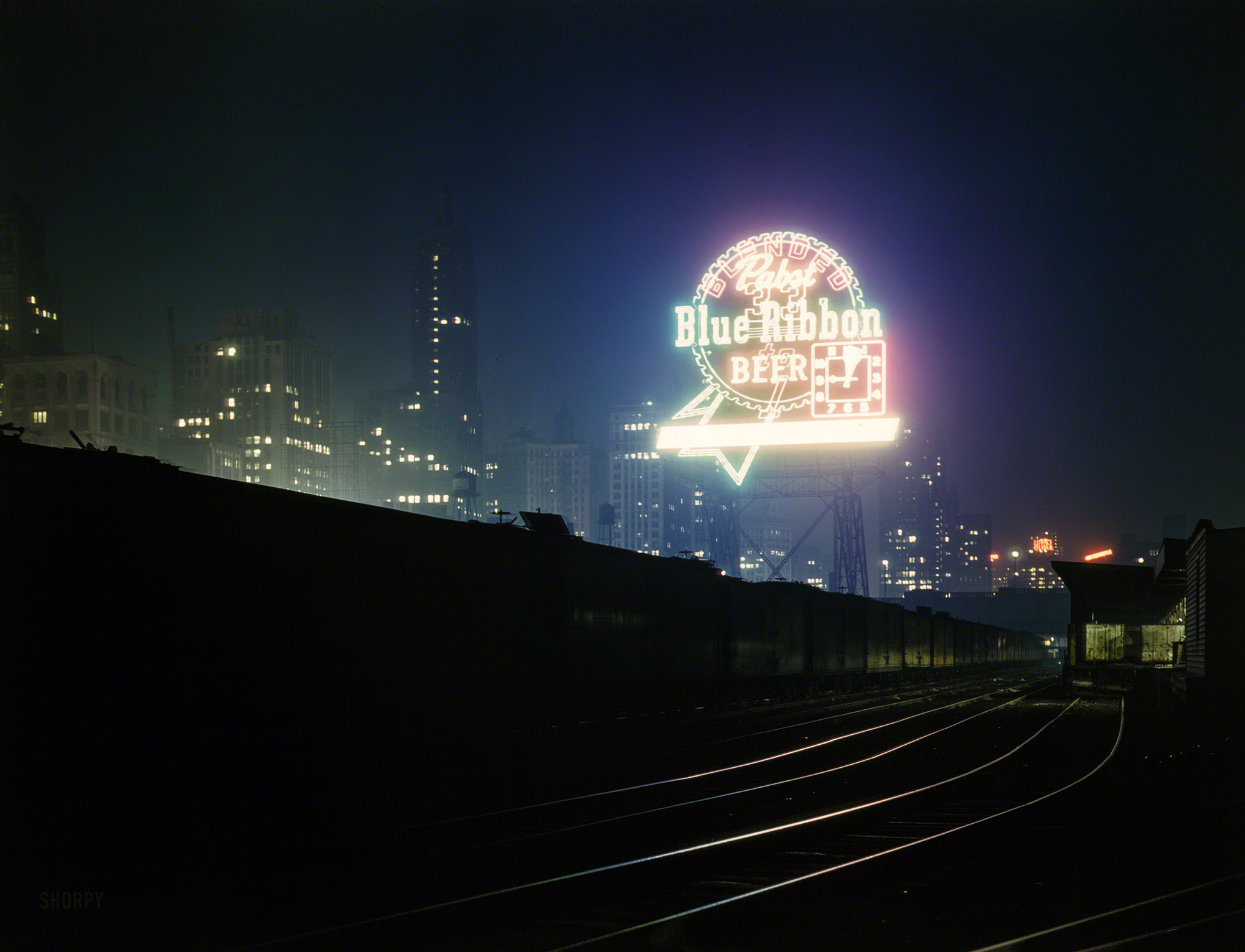 &nbsp; &nbsp; &nbsp; &nbsp; One of our first posts 10 years ago, enlarged and re-restored.
April 1943. "Illinois Central R.R. freight cars in South Water Street terminal, Chicago." Judging by the clock, this was a five-minute time exposure. Kodachrome transparency by Jack Delano for the Office of War Information. View full size.