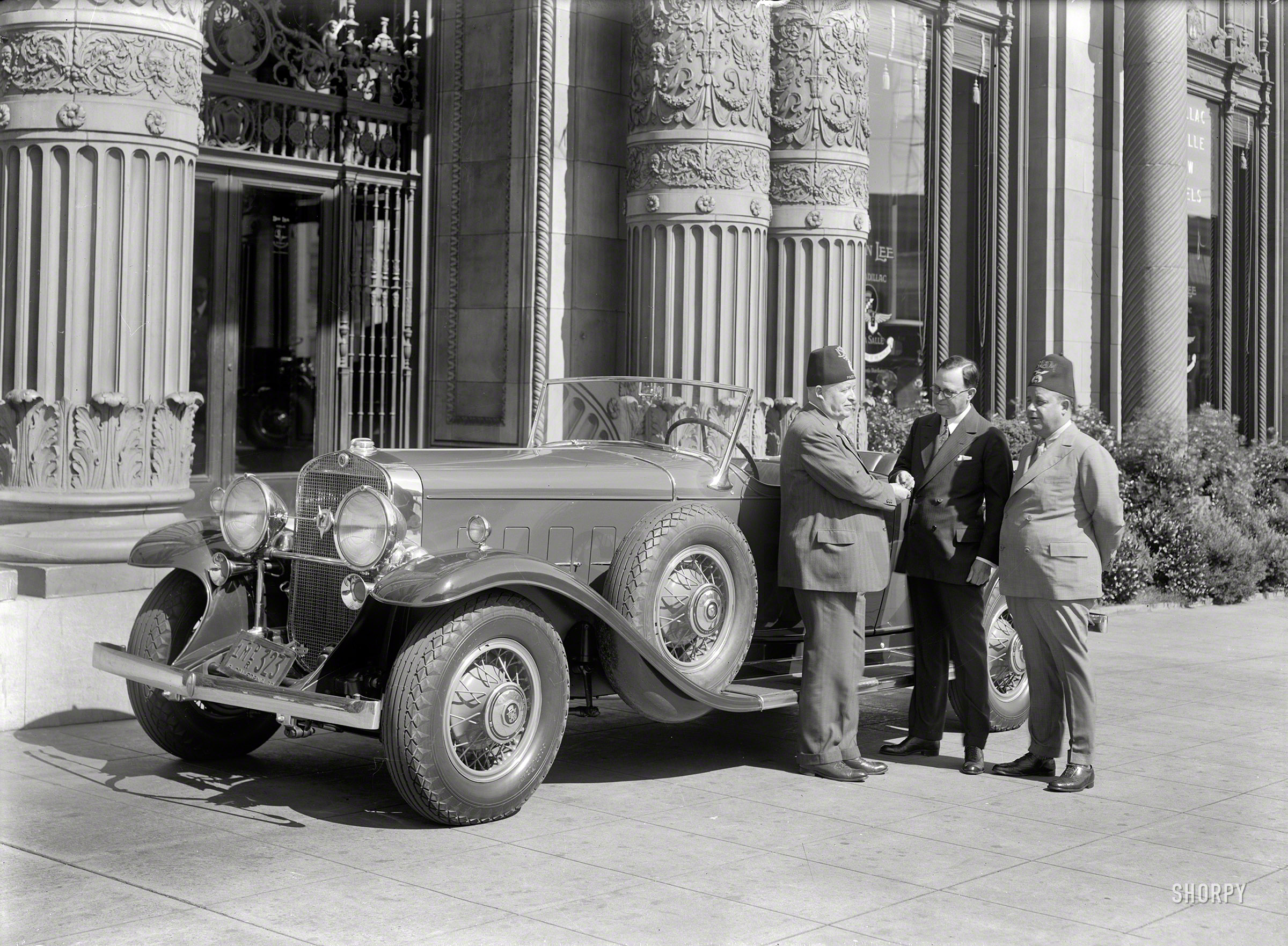 &nbsp; &nbsp; Don Lee handing over the keys to a V-12 Cadillac touring car.
San Francisco, 1932. "Cadillac agency, NE corner Van Ness & O'Farrell." The monumental exterior of Don Lee Cadillac. Note the "ISLAM" fezzes of these Masonic potentates. 5x7 glass negative by Christopher Helin. View full size.