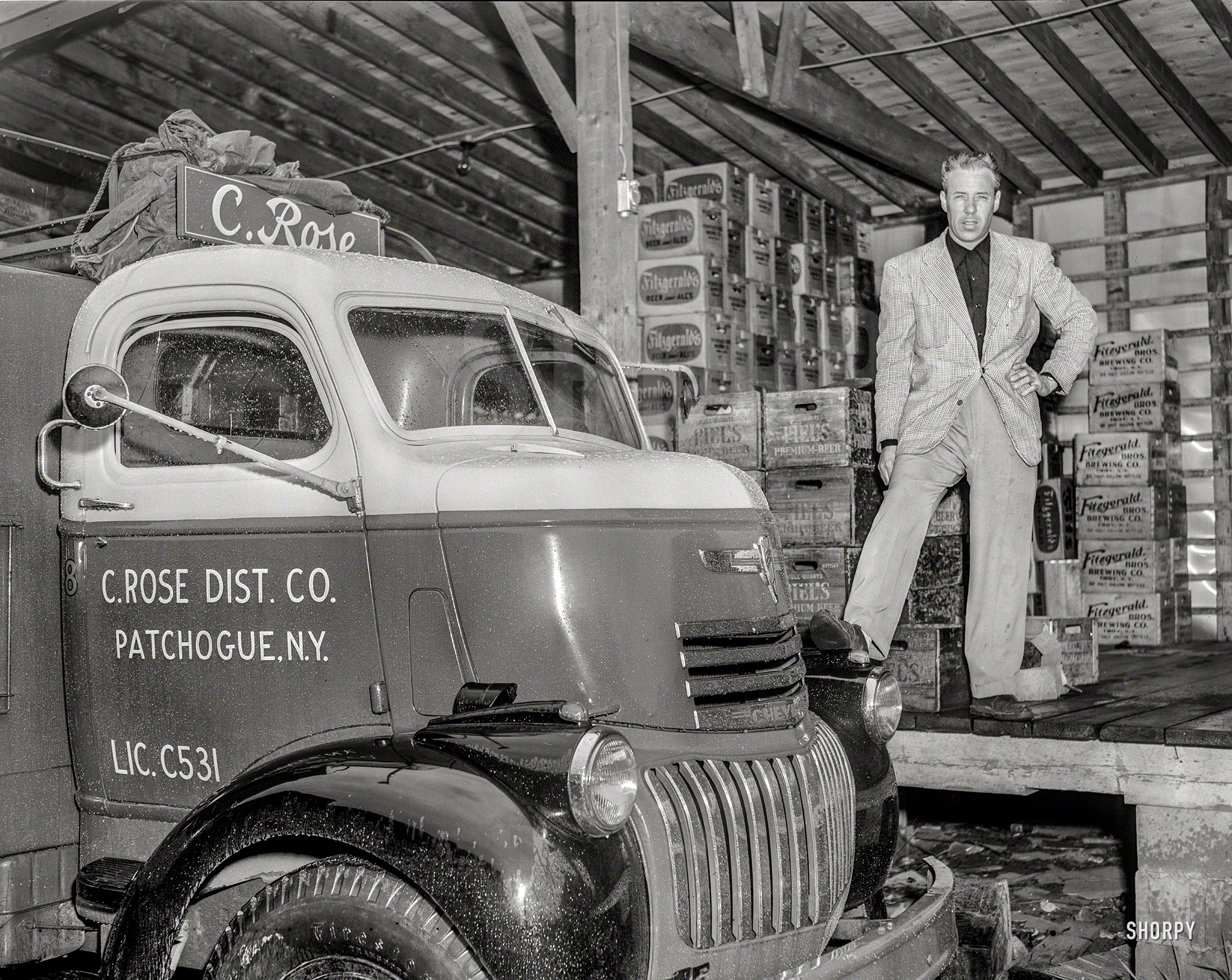 New York circa 1948. "C. Rose Distributing Co. truck." Just in out of the rain, with a backdrop of Piel's, Fitzgerald's, and maybe Rose himself. Who if he dressed any sharper might make your eyes bleed. 4x5 negative by John Fox. View full size.