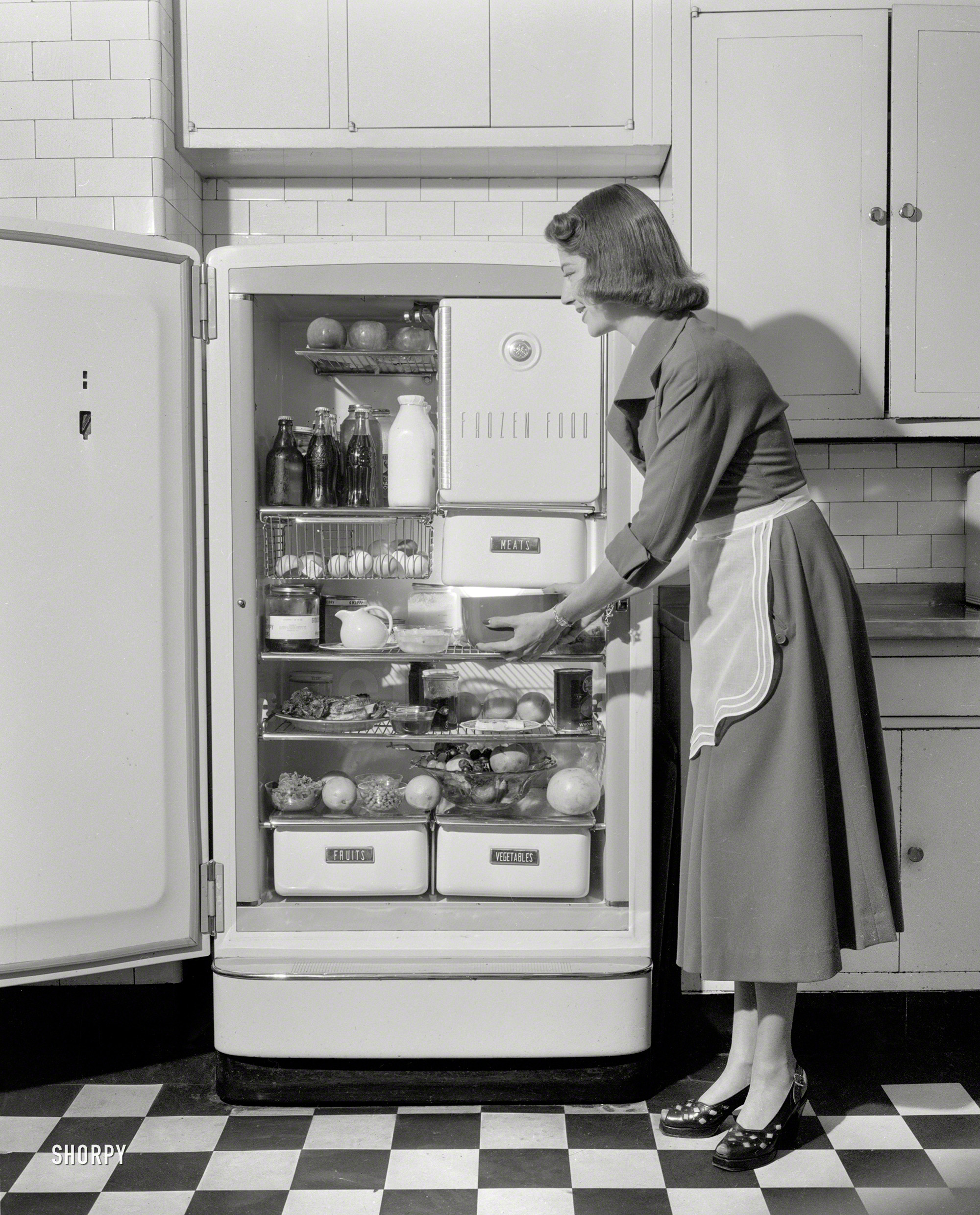 New York circa 1948. "Woman in kitchen with General Electric refrigerator." Yes, this dish should warm up nicely. 4x5 negative by John M. Fox. View full size.
