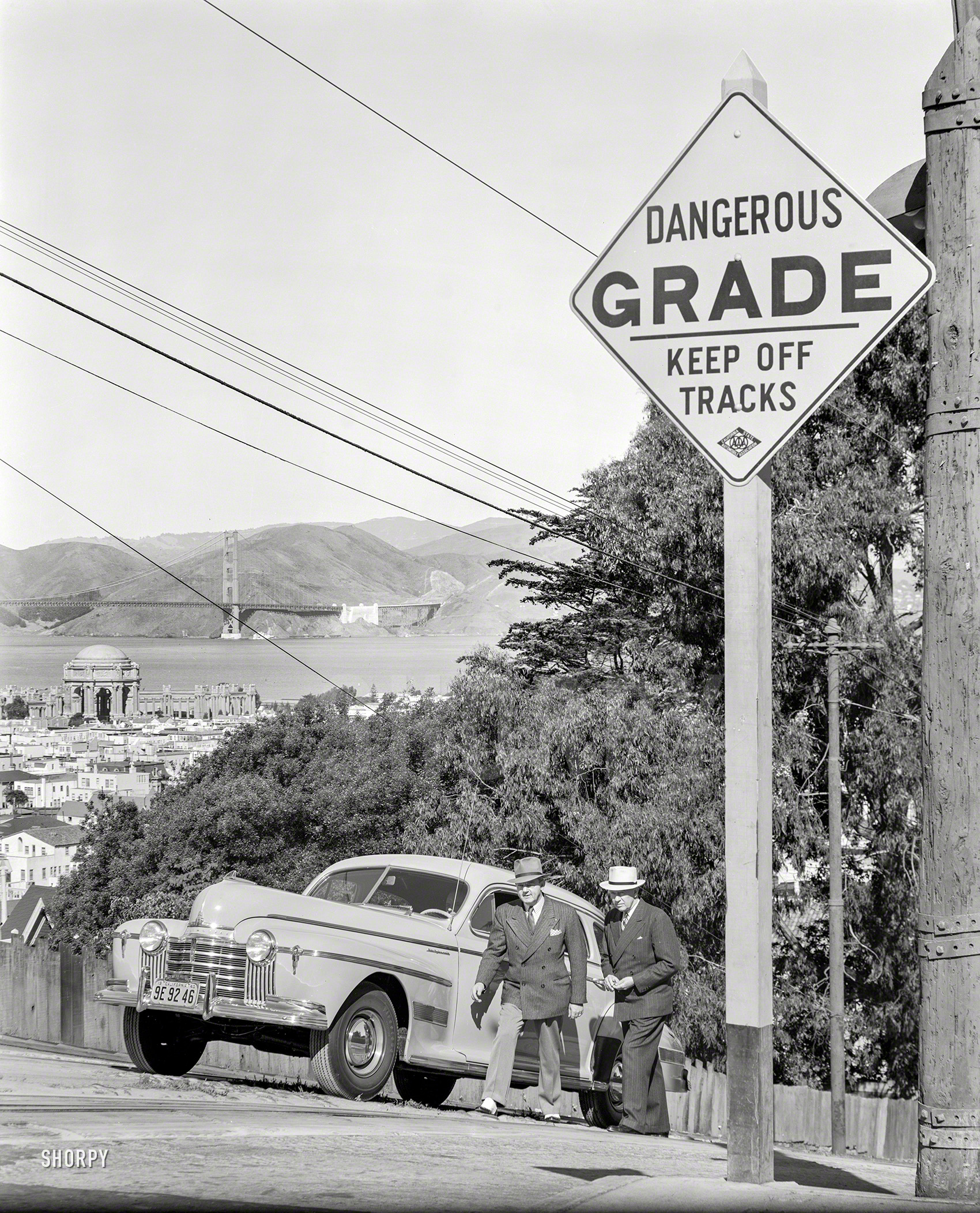 San Francisco, 1940. "Oldsmobile sedan and pedestrians ascending steep grade." With the Palace of Fine Arts and Golden Gate Bridge in the distance. 8x0 film negative, originally from the Wyland Stanley collection. View full size.
