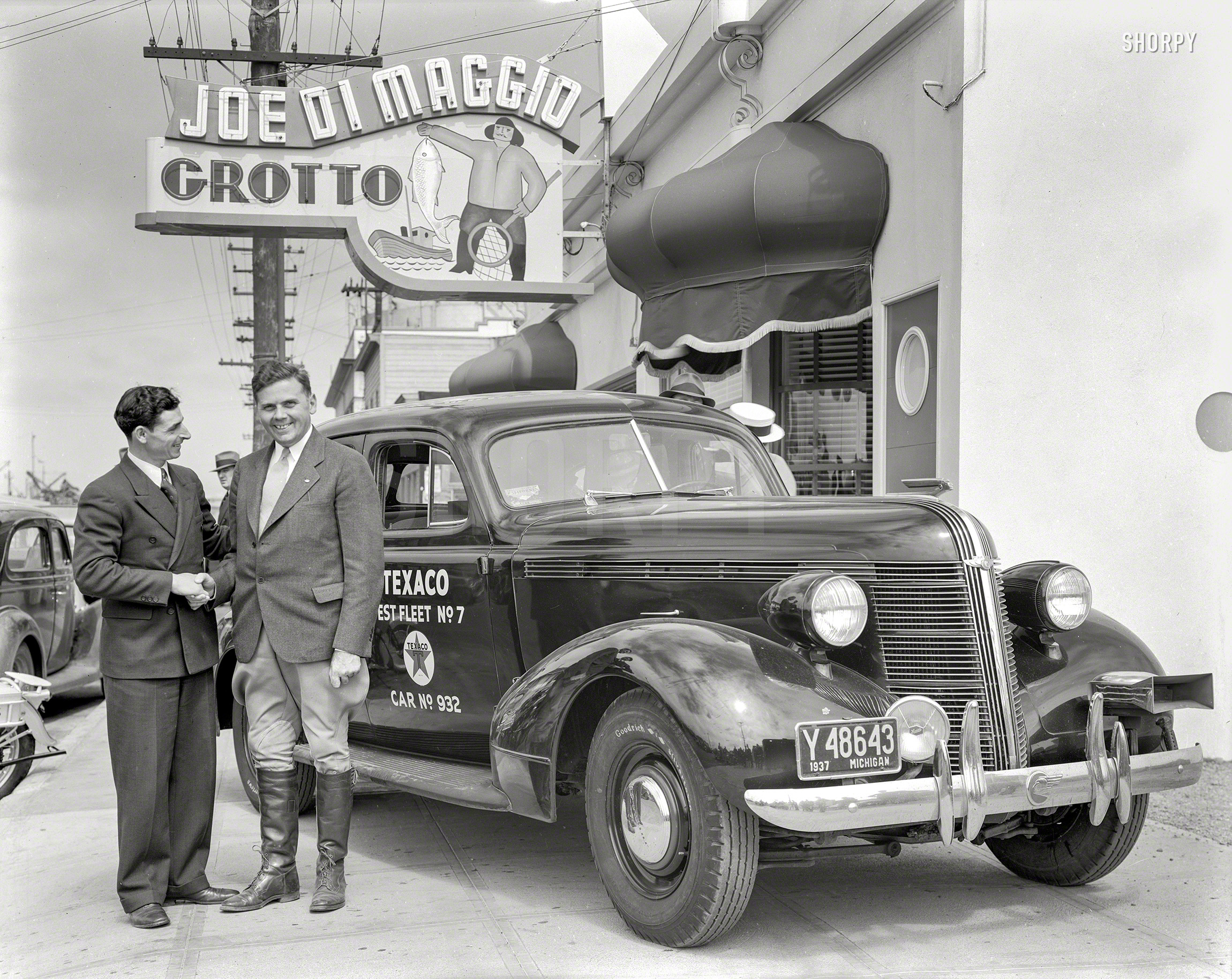 June 15, 1937. Fisherman's Wharf in San Francisco. "Texaco Test Fleet auto at Joe DiMaggio Grotto. Driver of Pontiac with restaurant manager Tom DiMaggio." 8x10 film negative from the Wyland Stanley collection. View full size.