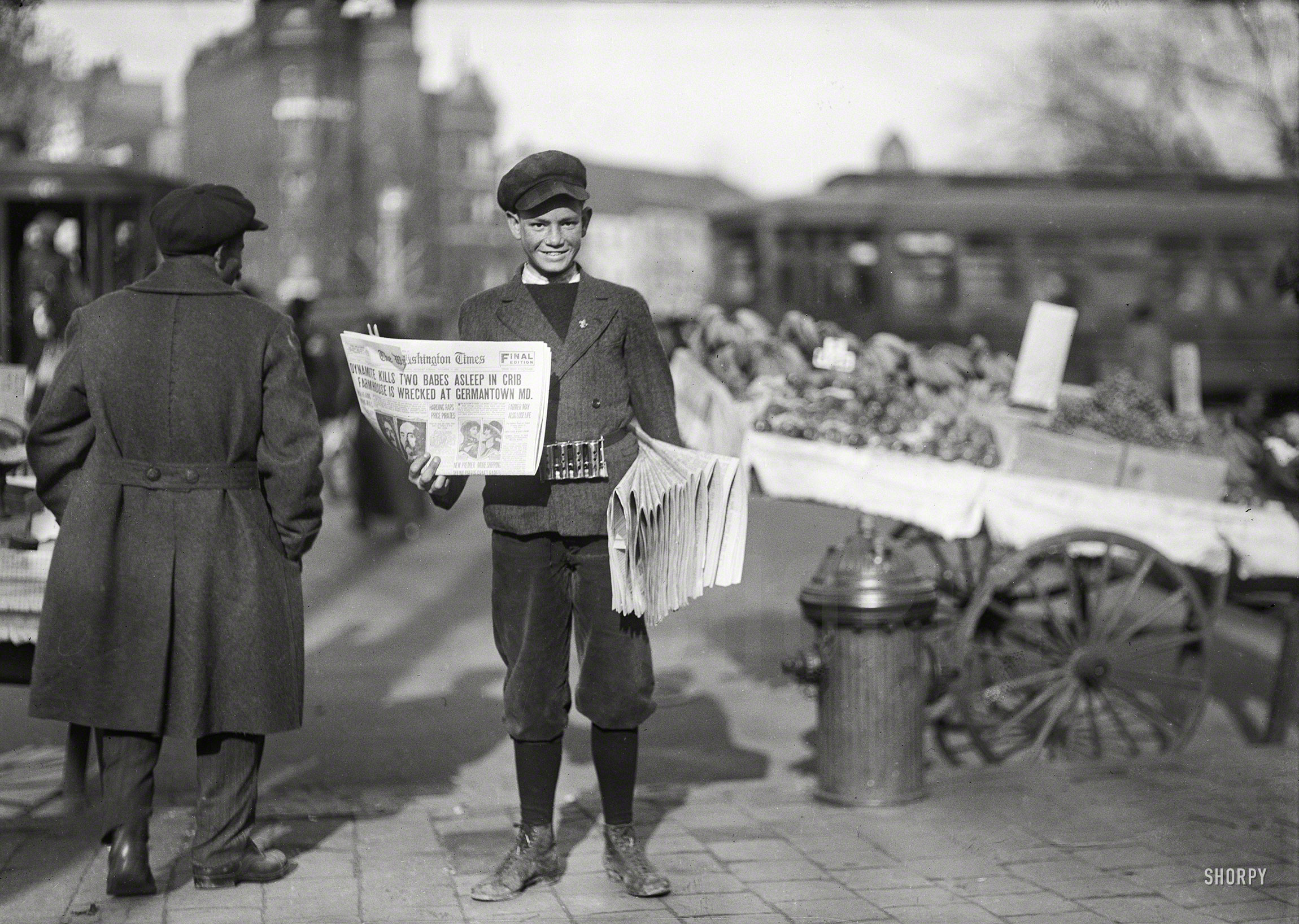 November 18, 1920. "Newsboy holding the Washington Times." Whose banner headline, DYNAMITE KILLS TWO BABES ASLEEP IN CRIB, summarizes a lurid crime that literally rocked Montgomery County, Maryland, in the fall of 1920 when a house painter engaged in a political feud with his neighbor, farmhand James Bolton, dynamited his bungalow, killing the man along with the two small children of his housekeeper. Guy Vernon Thompson was hanged for the crime the following April. Harris & Ewing Collection glass negative. View full size.