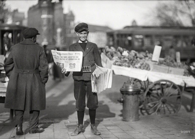 November 18, 1920. "Newsboy holding the Washington Times." Whose banner headline, DYNAMITE KILLS TWO BABES ASLEEP IN CRIB, summarizes a lurid crime that literally rocked Montgomery County, Maryland, in the fall of 1920 when a house painter engaged in a political feud with his neighbor, farmhand James Bolton, dynamited his bungalow, killing the man along with the two small children of his housekeeper. Guy Vernon Thompson was hanged for the crime the following April. Harris &amp; Ewing Collection glass negative. View full size.
