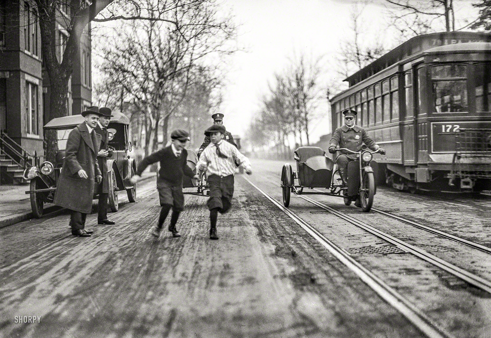 Washington, D.C., circa 1922. "NO CAPTION (Children, police motorcycles with sidecars, and streetcar in street)." From a series of photos whose subject seems to be traffic safety. Harris & Ewing Collection glass negative. View full size.
