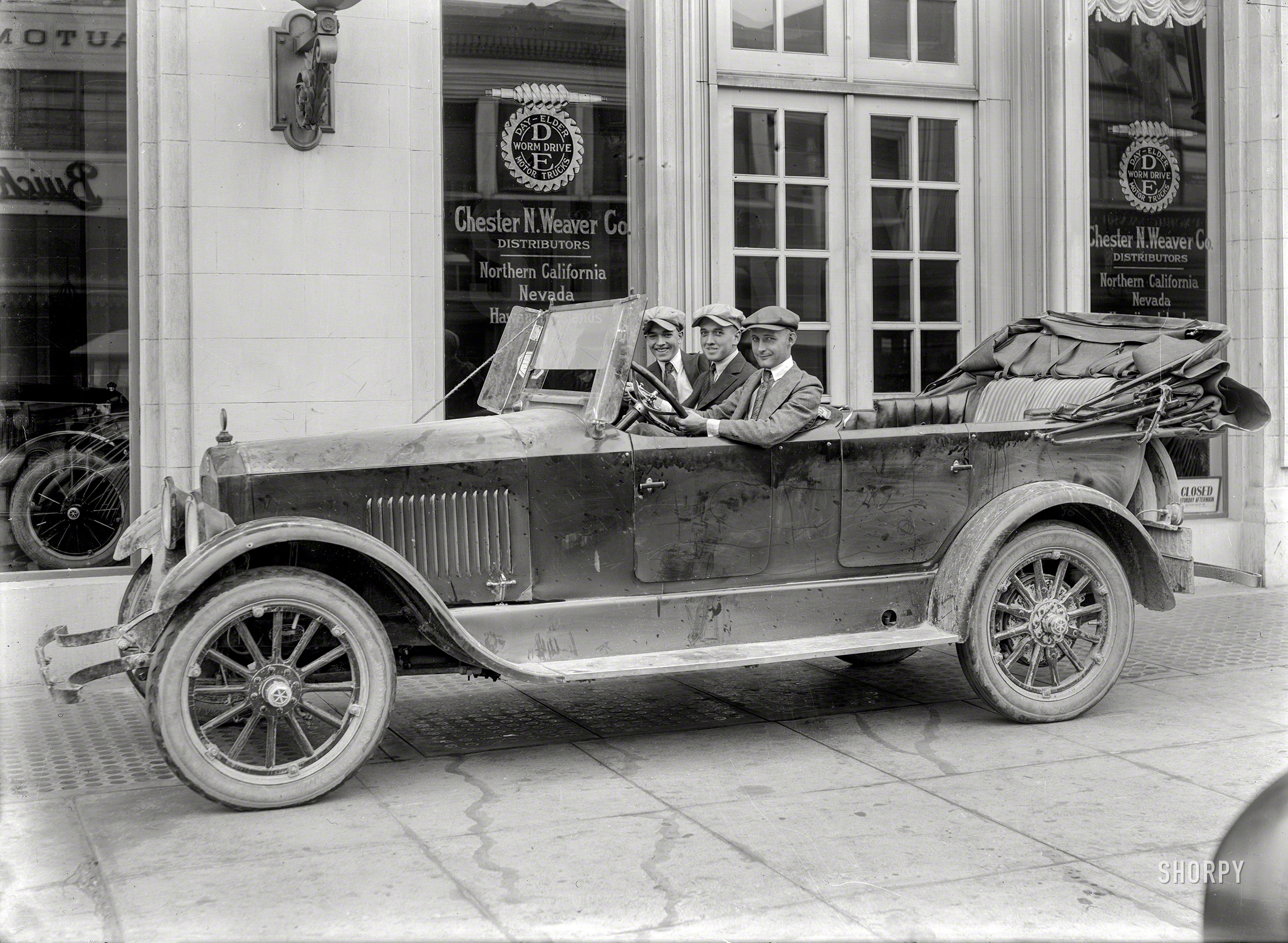 San Francisco circa 1920. Three gents in a dusty touring car with Arkansas and Colorado tags (and Yellowstone National Park windshield pass) are the stars of this 5x7 glass negative with the caption "Studebaker. Chester N. Weaver Co., S.E. corner Van Ness & California. Remodeled and occupied by Crocker-Citizens' Bank in 1967." Photo by Christopher Helin. View full size.