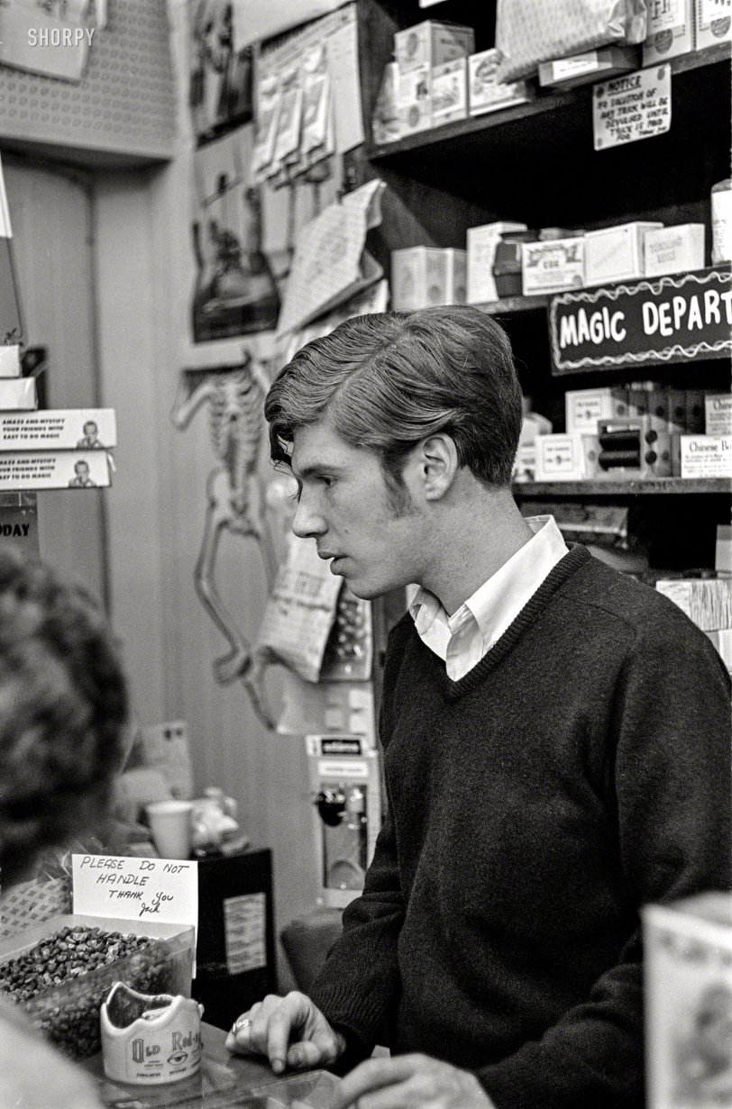 "Store clerk, Little Jack Horner joke shop, Boston, 1967." Please do not handle the Jumping Beans. 35mm negative, photographer unknown. View full size.
