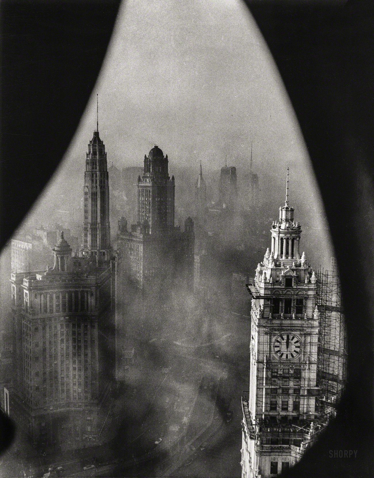 November 1, 1952. "Chicago framed by Gothic stonework high in the Tribune Tower. This view of Chicago's downtown shows the low-lying smog which blanketed the area one recent morning. In the foreground is the well-known Wrigley Building." Underwood & Underwood photo. View full size.