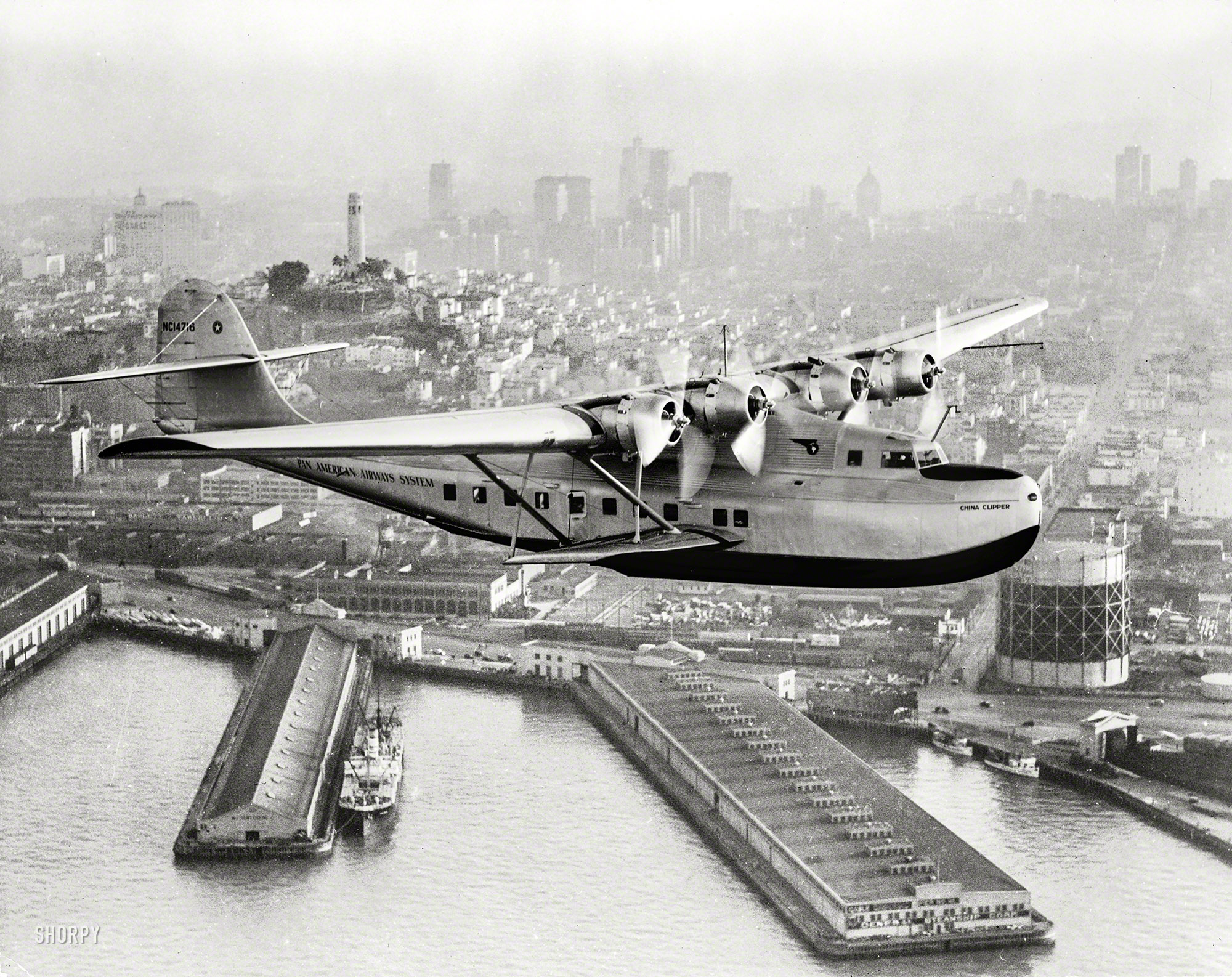 July 22, 1936. "Aerial view of Pan American Airways 'China Clipper' (Martin M130 Flying Boat) over San Francisco with Coit Memorial Tower at left. Clyde H. Sunderland, commercial and aerial photographs, Oakland, Calif." View full size.