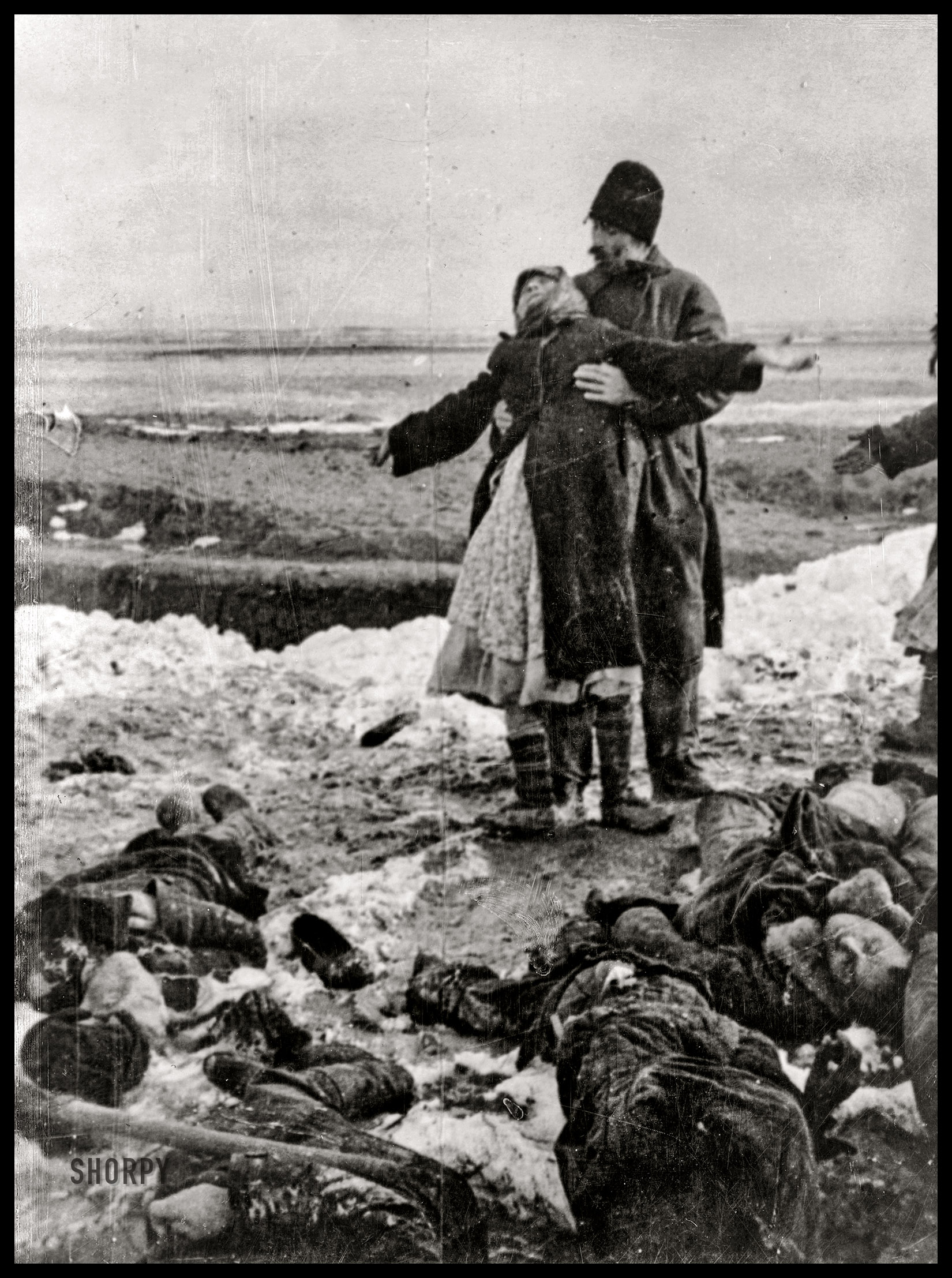 January 1942. Kerch Peninsula, Ukraine. "Parents find the body of their murdered son in Kerch. Photograph shows mother with arms outstretched, leaning back against husband while dead bodies lie at their feet." U.S. Office for Emergency Management photoprint -- British Official Photo (German War Crimes -- Hitler -- World War II). View full size.