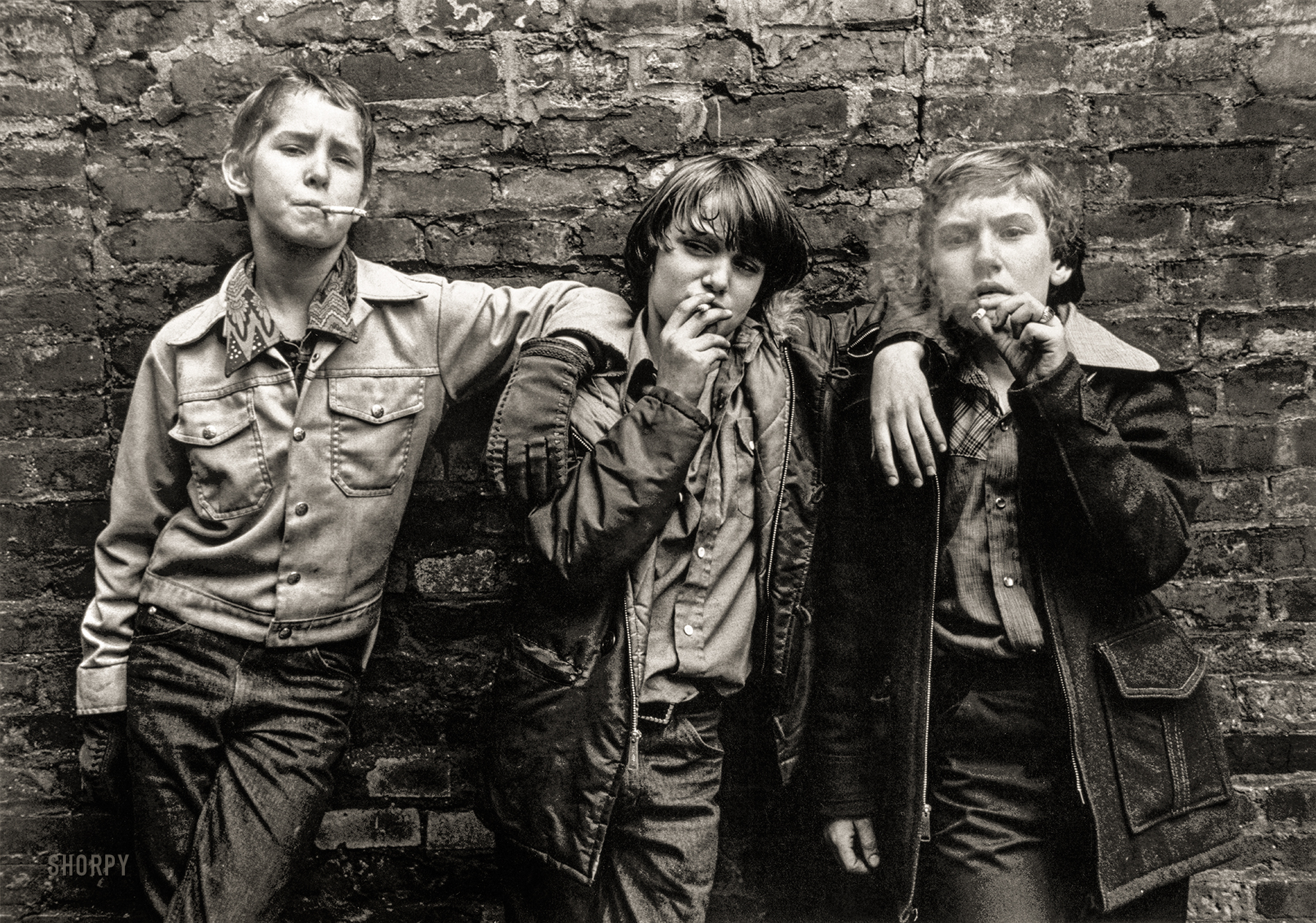 New York City, 1975. "Three boys with tough expressions smoking cigarettes." Compare with Lewis Hine's photo Skeeter's Branch Newsies, from 65 years earlier. Gelatin silver print by William J. Cunningham. View full size.