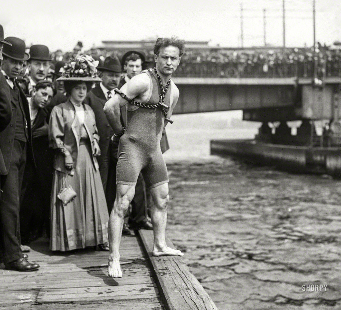 April 30, 1908. The Charles River in Boston. "Houdini in chains and handcuffs before jumping from Harvard Bridge." Photo by John Thurston. View full size.