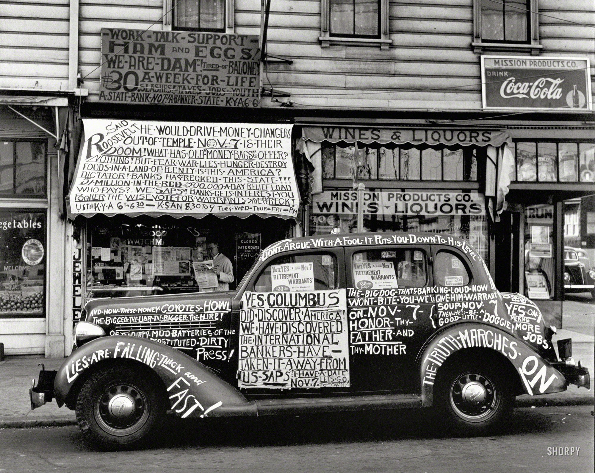 San Francisco, 1938. "Yes, Columbus Did Discover America!" A jeweler (and car) with definite political views. Gelatin silver print by the German-born painter and photographer John Gutmann (1905-1998). View full size.