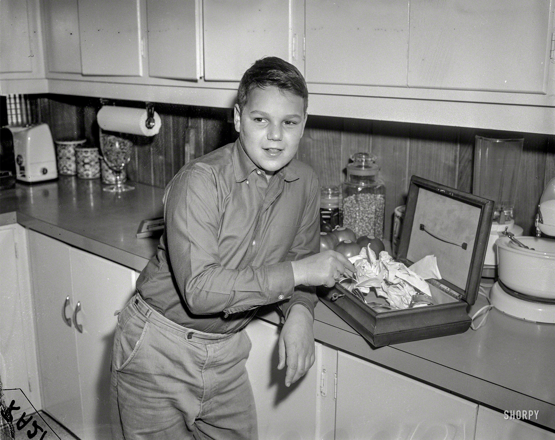 Chicago circa 1958. "Crime" is all it says on this News Archive photo -- a whodunit whose clues are a boy, a kitchen, a box and some handcuffs. View full size.
