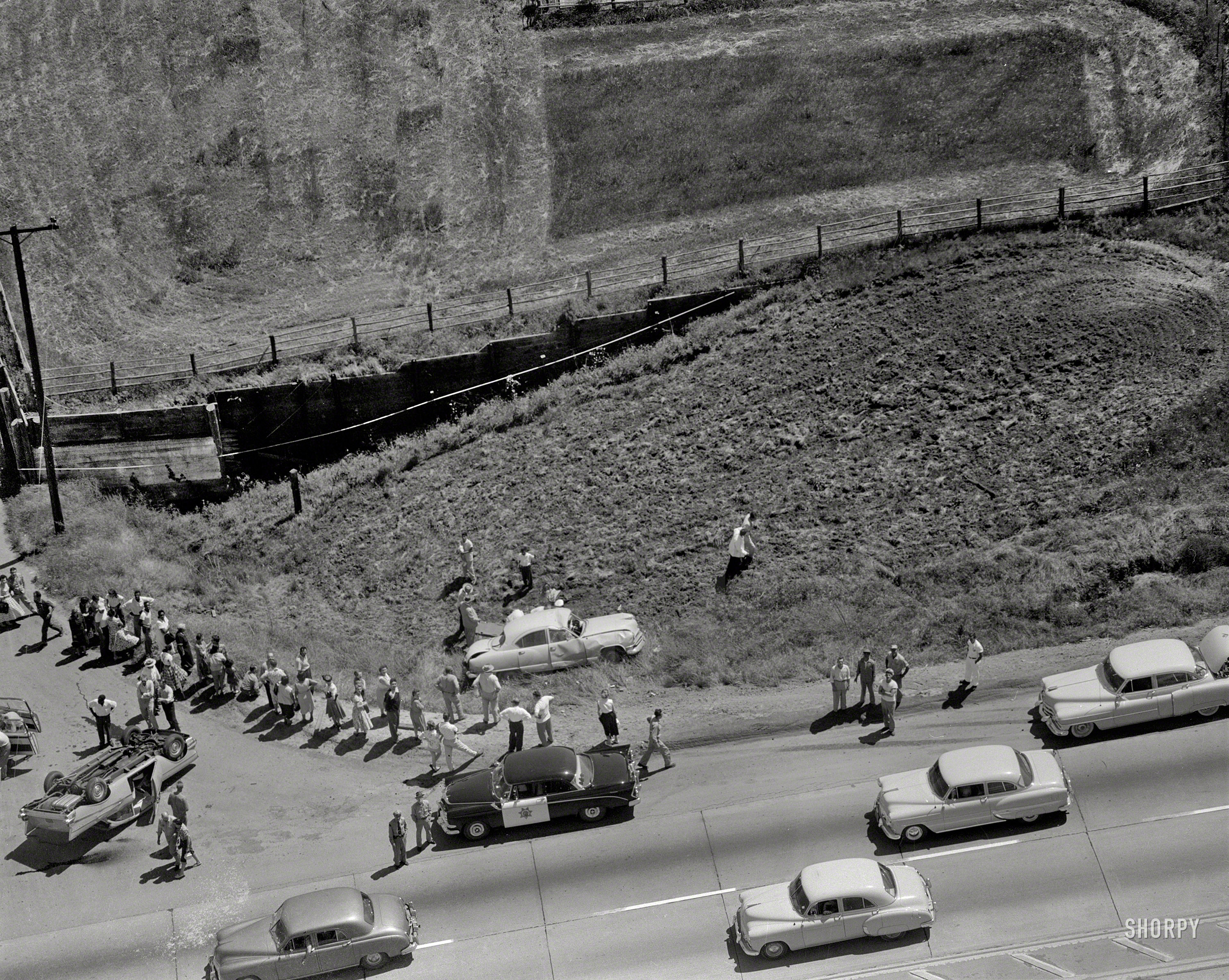 Oakland, California, circa 1957. "Collision aerial." Aftermath of a crash between a Kaiser sedan (one of two in this photo) and a 1957 Chevy coupe. View full size.