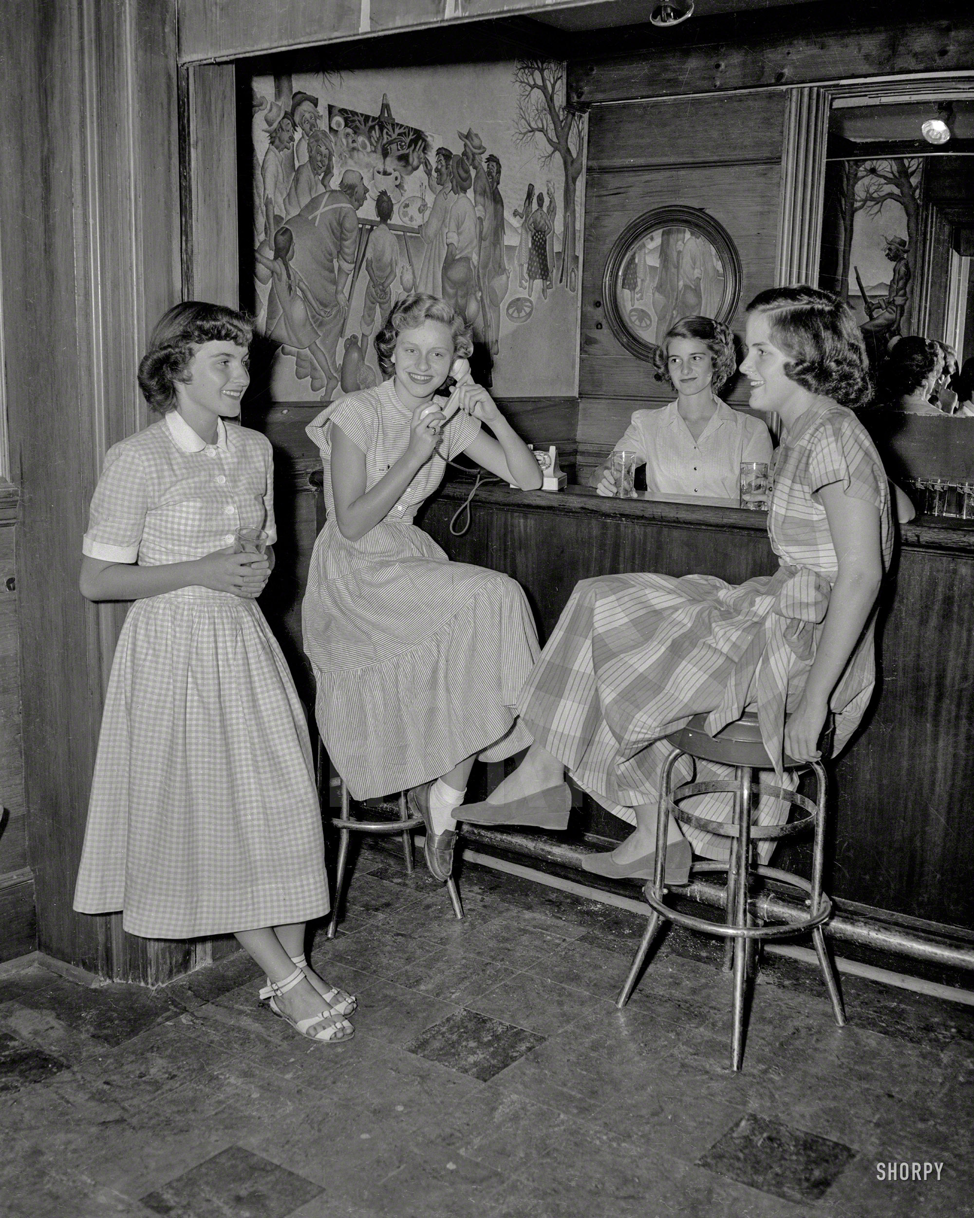 Georgia circa 1956, and some Junior League types at a country-clubby looking bar with an unusual picture-in-picture mural. The tumblers say "Auburn." 4x5 acetate negative from the News Photo Archive. View full size.