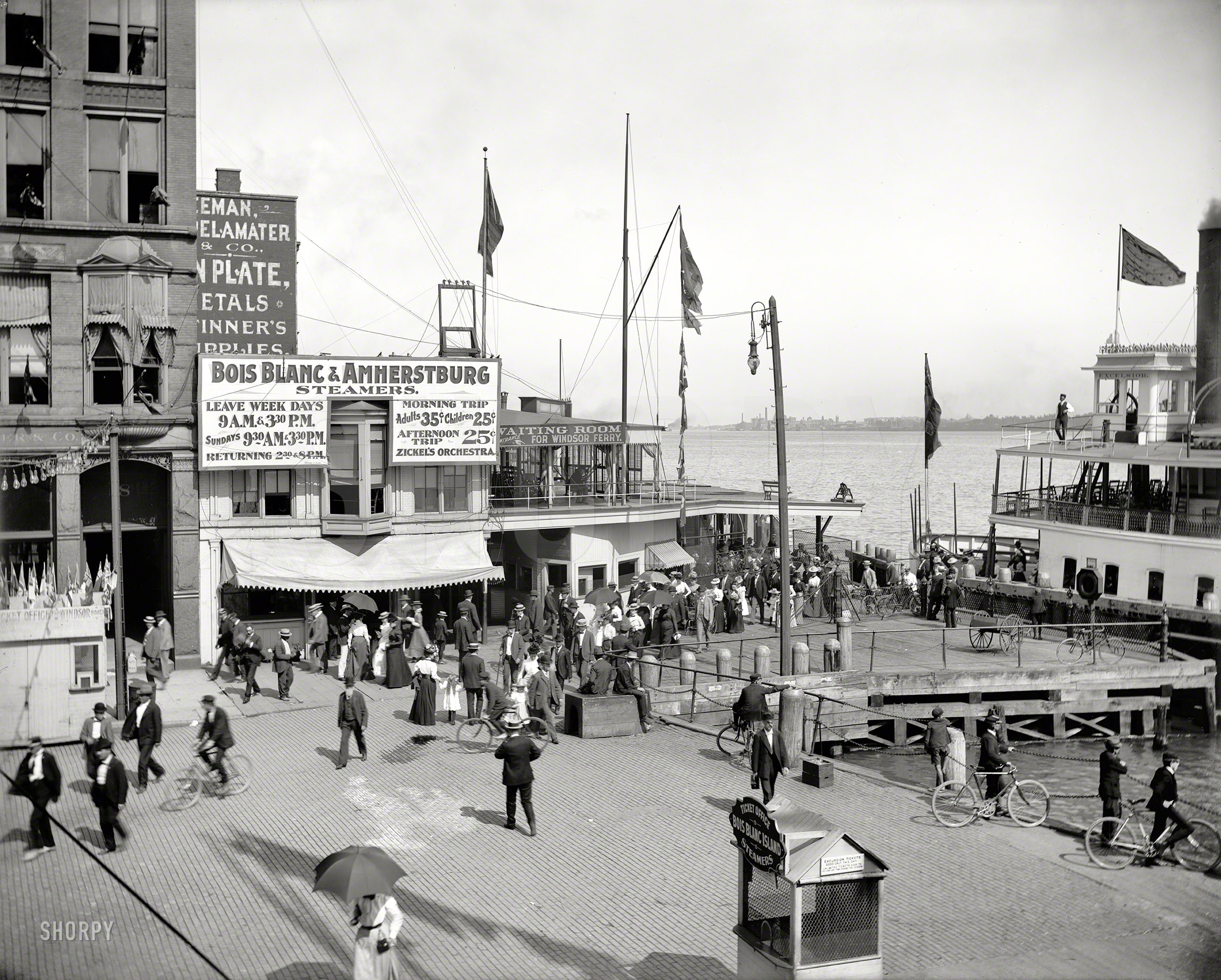 Detroit circa 1901. "Windsor ferry dock, Woodward Avenue. Steamers to Bois Blanc Island (Boblo Island), Ontario." We're signed up for the 3:30 excursion, but only if Zickel's Orchestra is playing. 8x10 glass negative. View full size.