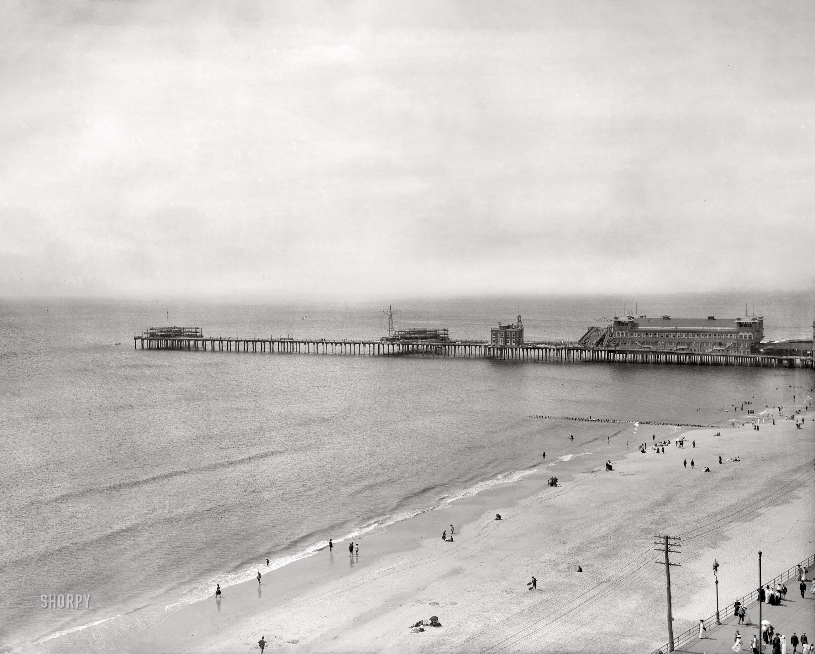 1907. "Atlantic City Boardwalk (lower right) and Young's Million-Dollar Pier." Out on the pier just beyond Marine Hall, and modeled after a popular Coney Island ride, is an attraction called The Tickler ("The big tubs go bowling their curious way down the incline, loaded with happy, laughing passengers," according to an item in the Atlantic Review). This image, a continuation of yesterday's Atlantic City panorama, shows at least two box kites on what must have been a windy day. 8x10 inch dry plate glass negative, Detroit Publishing Company. View full size.