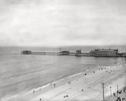 1907. "Atlantic City Boardwalk (lower right) and Young's Million-Dollar Pier." Out on the pier just beyond Marine Hall, and modeled after a popular Coney Island ride, is an attraction called The Tickler ("The big tubs go bowling their curious way down the incline, loaded with happy, laughing passengers," according to an item in the Atlantic Review). This image, a continuation of yesterday's Atlantic City panorama, shows at least two box kites on what must have been a windy day. 8x10 inch dry plate glass negative, Detroit Publishing Company. View full size.
Sense of loneliness ...A few scattered figures at the water's edge are only the reminder that our beloved "actors" of this photo have left the stage.
TickledIs this the same Tickler as seen in Cincinnati a couple years later?
https://www.shorpy.com/node/8631
Westerly BreezeJudging by the angle of the blown skirts, it was a westerly breeze, blowing in from Pennsylvania, across the Jersey Shore, and out to sea.
(The Gallery, Atlantic City, DPC, Swimming)