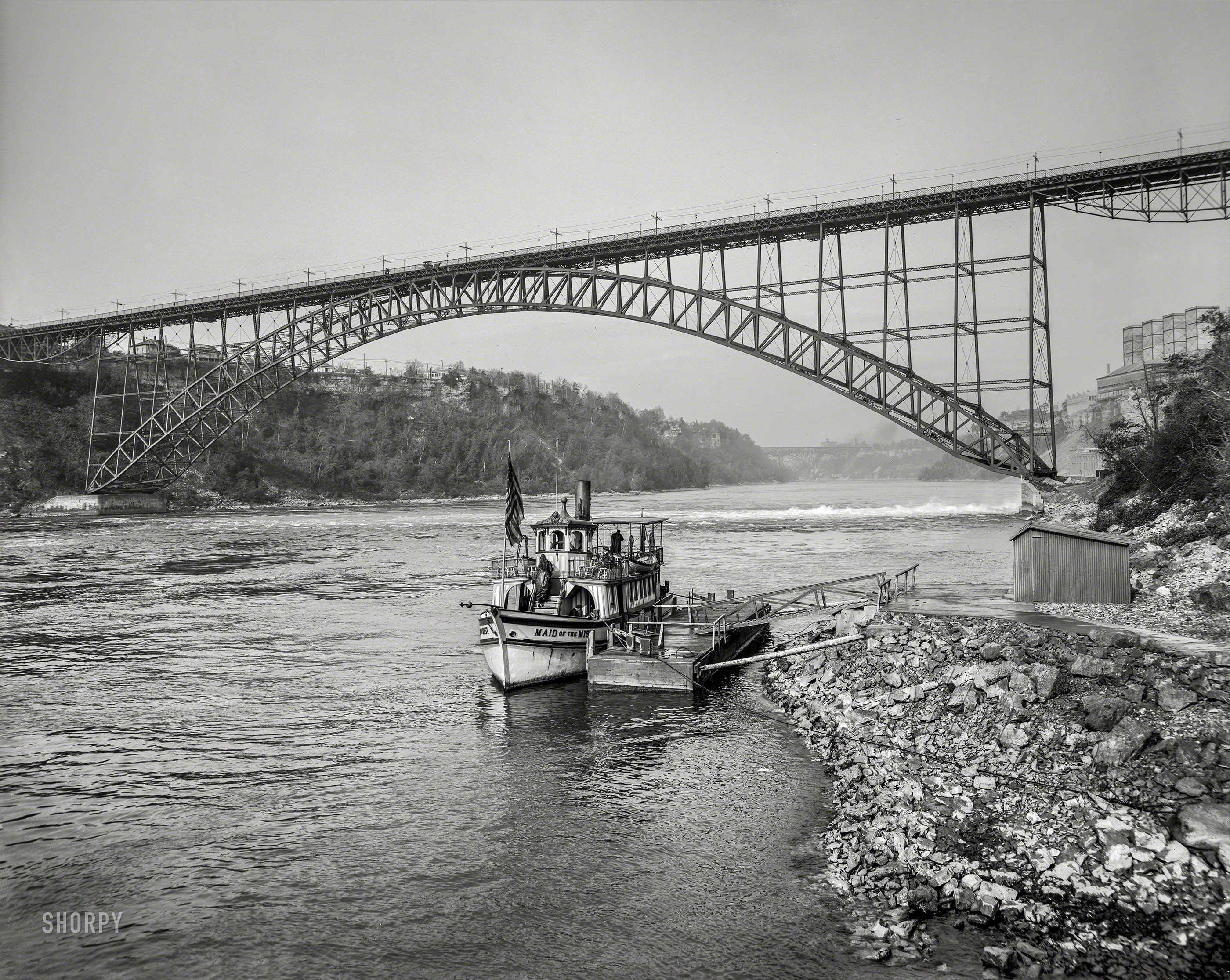 The Niagara River circa 1901. "International (Upper Steel Arch) Bridge from below at Niagara Falls." At the landing: The steamboat Maid of the Mist, "nymph of the mighty cataract." 8x10 inch dry plate glass negative. View full size.