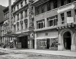 New York, 1913. "Quality Shop and Hudson Theatre." Where the audience for Bayard Veiller's drama The Fight included a grand jury probing charges that the play was "indecent and a public nuisance." 8x10 glass negative. View full size.
The alphabet thiefis in town - see usiness en's unch.
I certainly hopethat those two usiness en enjoy their unch at Café Signage.
Business Men&#039;s LunchThree martinis and some pretzels.
Quality Replacement Letters could probably be purchased at the aptly named, and handily located, shop a mere two doors down.
[The letters are not actually missing, they're just semi-invisible thanks to the emulsions used in the days before panchromatic film. - Dave]
Red BMLI would surmise, as letters painted with that color would show up darker when using orthochromatic emulsion (no guess as to Pantone color shade though.) 
Hudson Theatre is still thereIt's still in business at 141 W. 44th Street.  After serving as a movie theater, studio for CBS and NBC, a legitimate theater, a porno house and finally a rock night club, the NYC Landmarks Preservation Commission declared the interior and exterior an official landmark in 1987.  Now restored to its original 1903 appearance, the Hudson is part of the Millennium Broadway Hotel next door, and is used as a conference center and venue for special events.

Leo. Feist, Inc.Above the theater is one of the offices of Leo. Feist, Inc., as shown on the open windows and also by the large brass plate on the corner of the building. Leopold Feist founded and ran a music publishing firm in the early 1900s. By the 1920's, Feist was among the seven largest publishers of sheet music in the world. He had offices in major cities around he globe. His largest selling  piece of sheet music was "My Blue Heaven" published in 1927. Emblazoned -- at least once on every music sheet he published -- was the slogan "You Can't Go Wrong With Any Feist Song". After his death in 1930, most of the Feist music catalog was acquired by MGM. 
ComstockeryAccording to John Houchin's "Censorship of the American Theatre in the Twentieth Century", many early twentieth-century plays dramatized female sexual abuse (fueled by a moral panic over "white slavery"). What the authorities took exception to in "The Fight" was a confrontation set in a bordello, where the heroine (campaigning for public office) accuses her opponents of corrupting young women and the community for their own profit. In anticipation of the grand jury's visit, Veiller rewrote the second act and merely described the bordello scene, instead of showing it onstage, and after viewing the revised version, the grand jury dropped all charges.
(The Gallery, NYC, Stores & Markets)