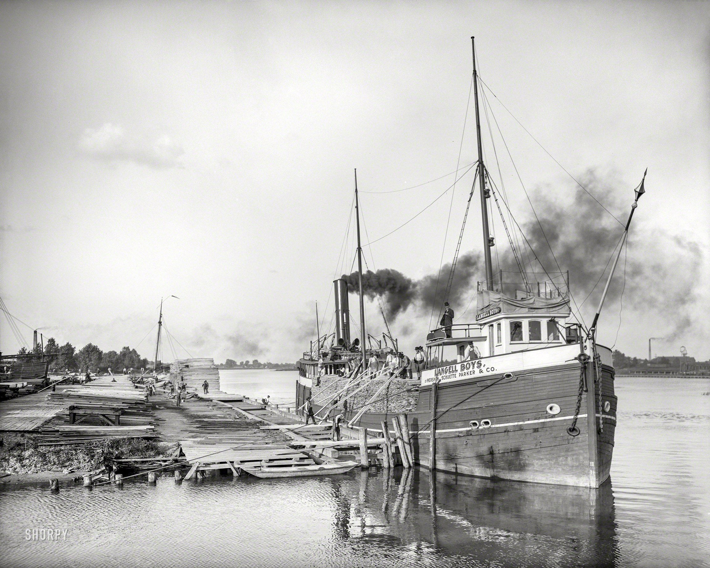 &nbsp; &nbsp; &nbsp; &nbsp; Named for the seven sons of shipbuilder Simon Langell, the steam barge "Langell Boys", launched in 1890, hauled lumber until she burned and sank in Lake Huron in 1931.
Circa 1908. "Lumber hooker Langell Boys unloading at Saginaw, Michigan." 8x10 inch dry plate glass negative, Detroit Publishing Company. View full size.