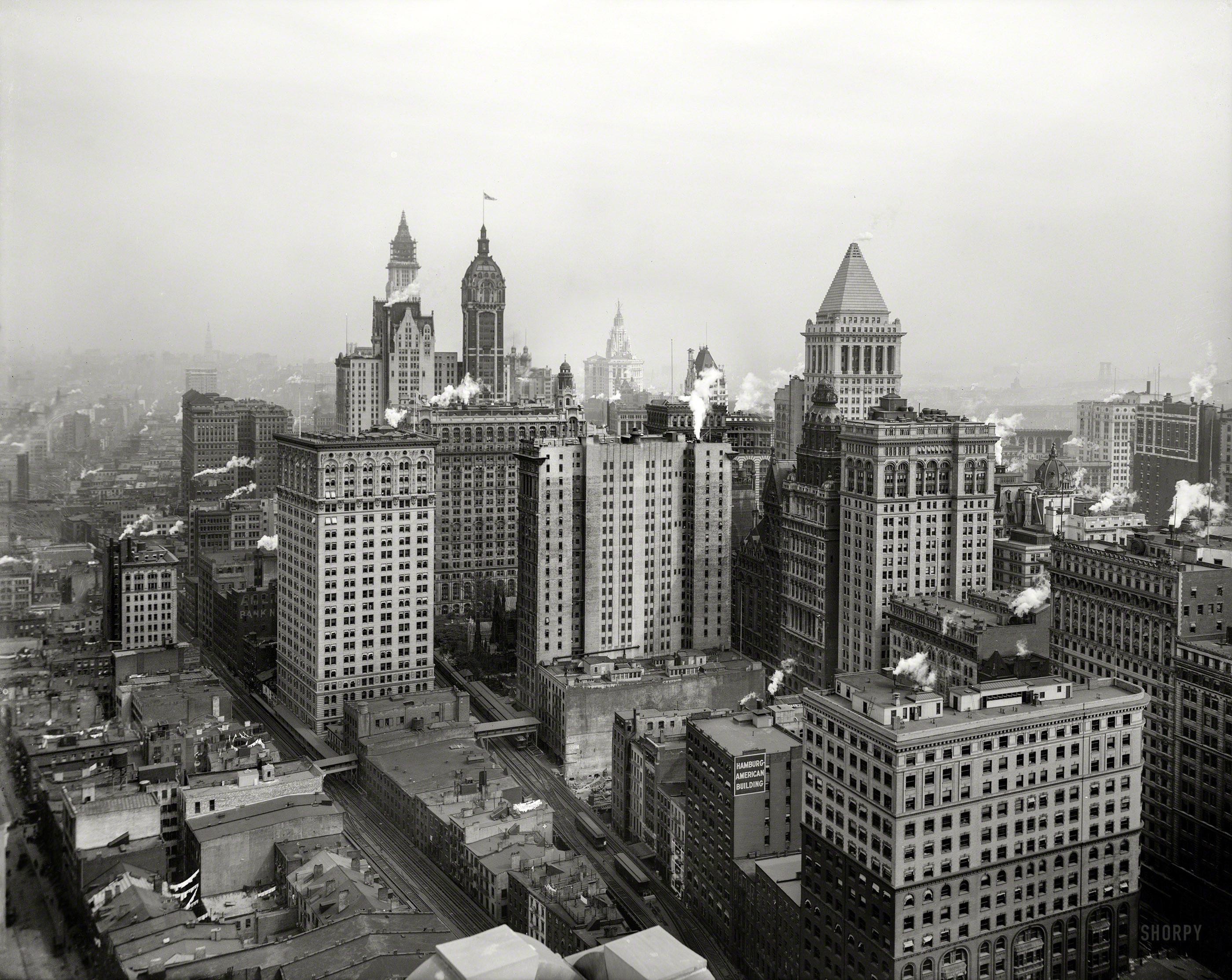 New York circa 1912. "Big buildings of Lower Manhattan." Notable skyscrapers (in a scene last glimpsed here) include the Woolworth tower (under construction), the Singer Building and the Bankers Trust pyramid. View full size.