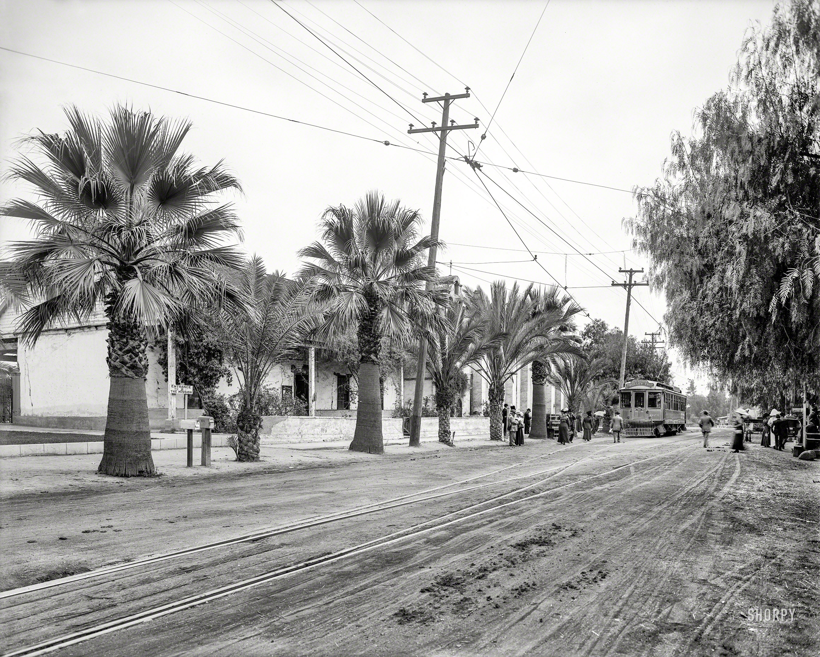 Circa 1912. "Old Mission Trolley Trip -- Pacific Electric Railway." The San Gabriel Mission near Los Angeles.  8x10 inch dry plate glass negative, Detroit Publishing Company. View full size.