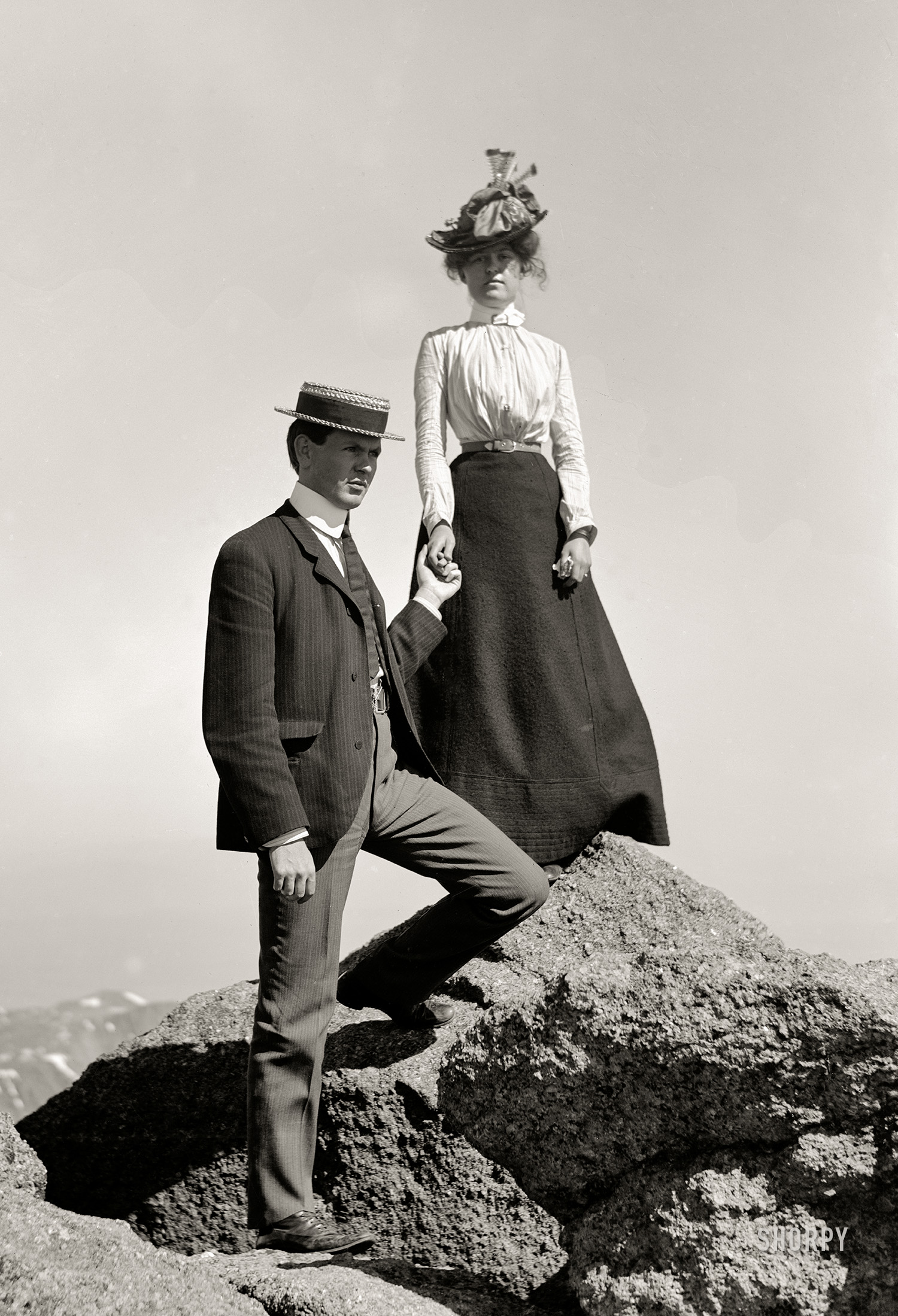 Somewhere mountainous circa 1910. "Young couple on rock holding hands, full-length portrait." 5x7 inch dry plate glass negative, Detroit Publishing Company. View full size.