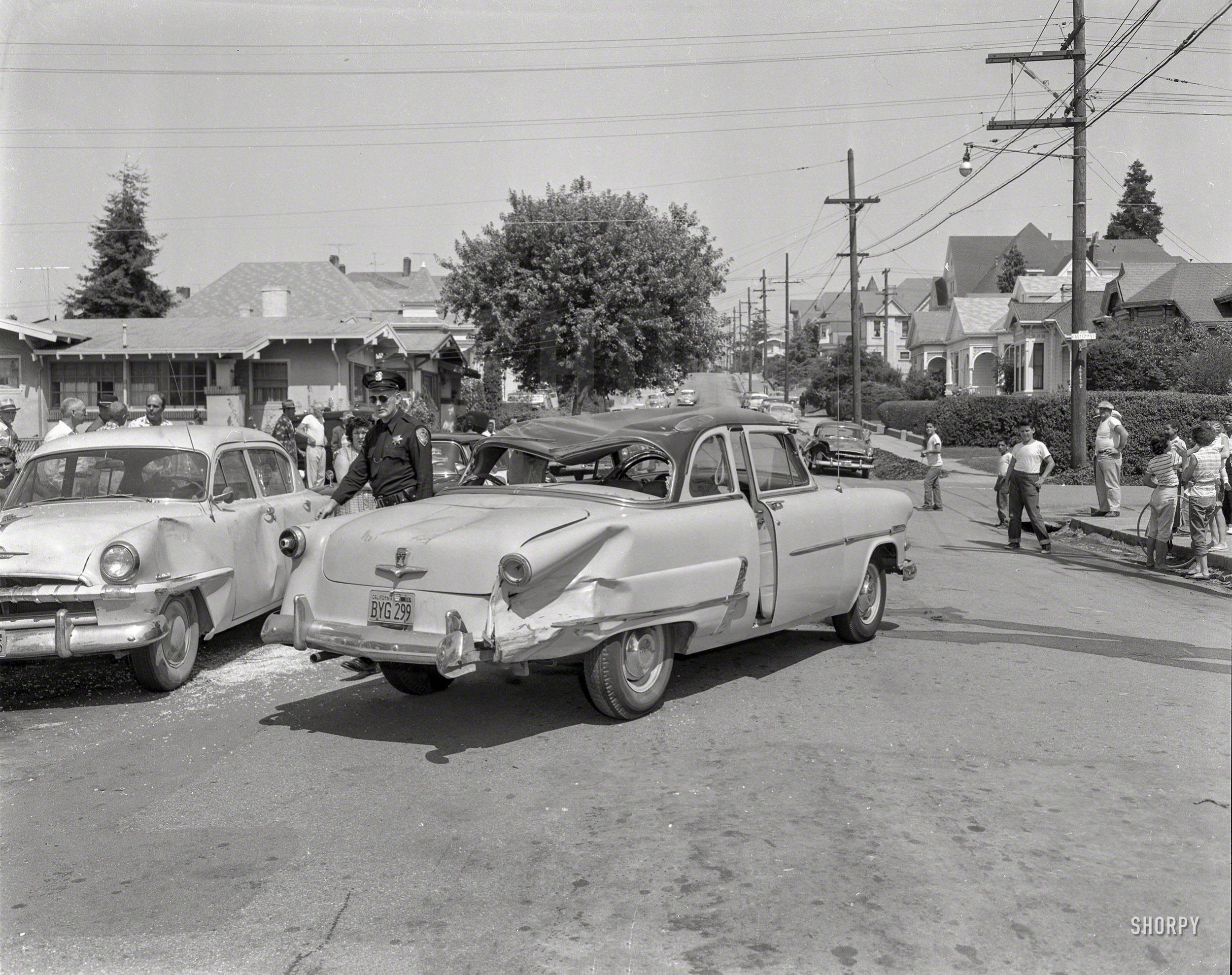 Plymouth vs. Ford on the streets of Oakland circa 1957, with a battered bystander in the distance. 4x5 safety negative from the News Archive. View full size.